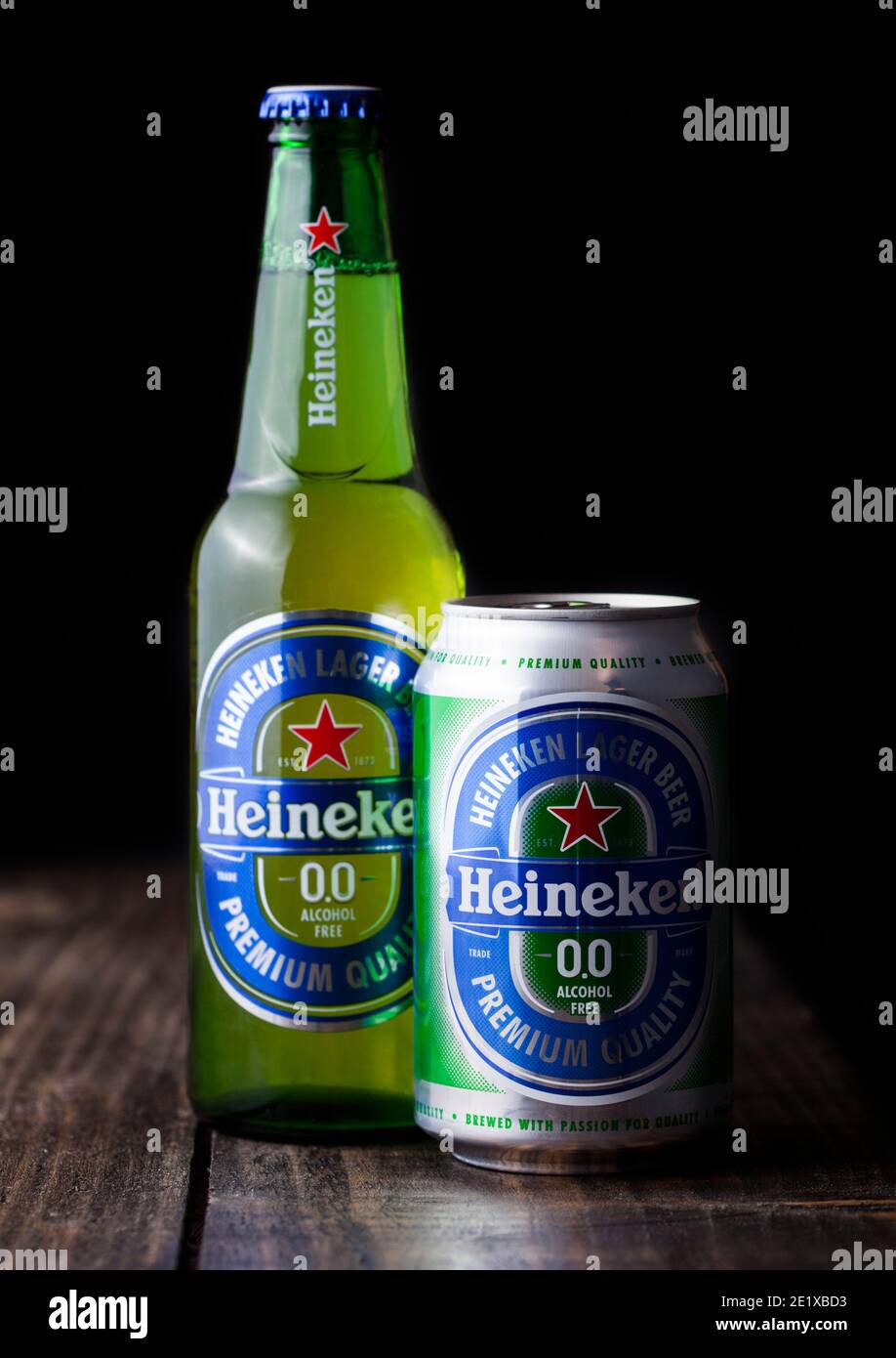 LONDON, UK - APRIL 27, 2018: Bottle and aluminium can of Heineken Alcohol free Lager Beer on dark wooden background. Heineken is the flagship product Stock Photo