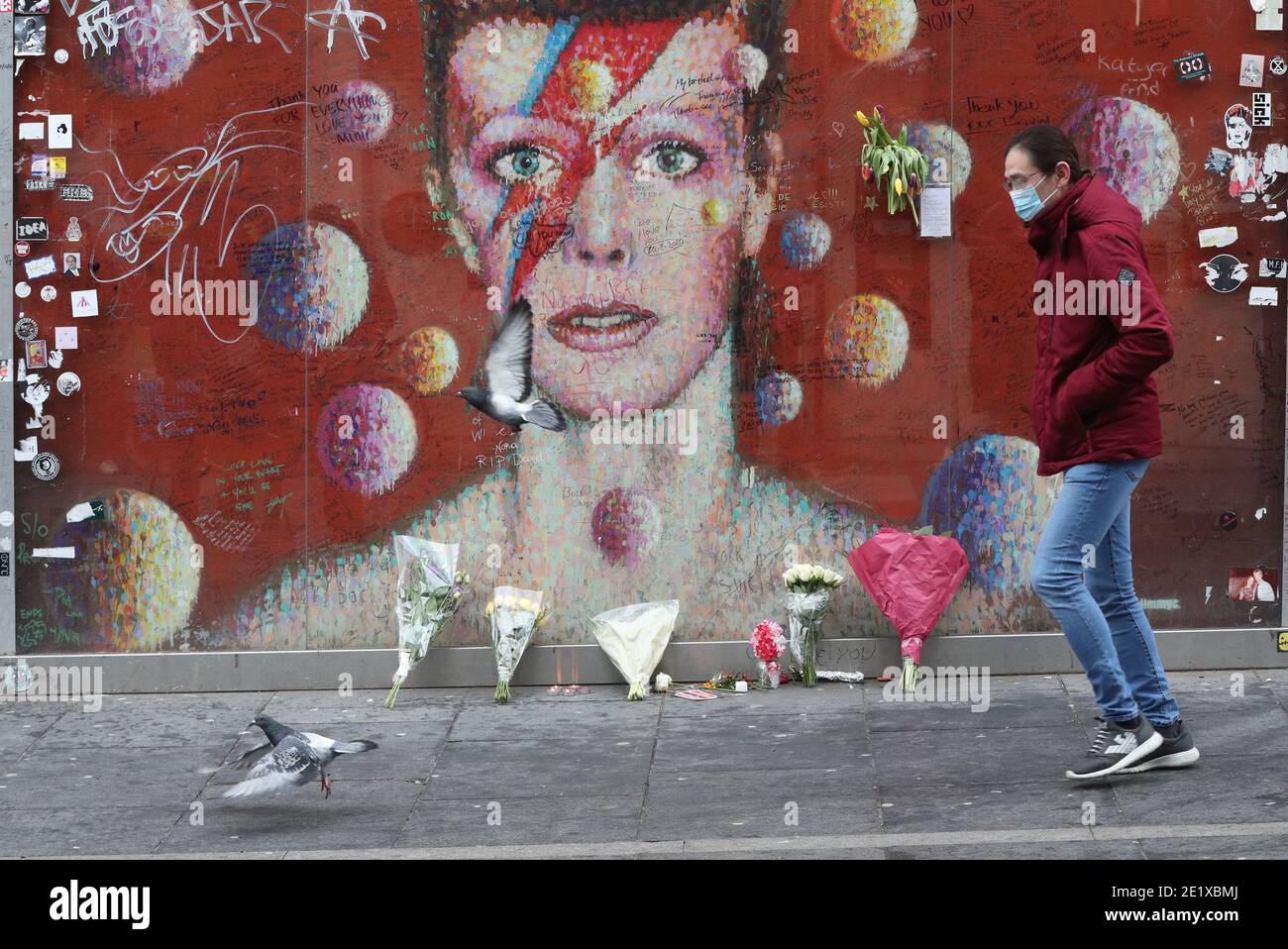 A person walls past the David Bowie mural in Brixton, south London on the fifth anniversary of the singer's death. Stock Photo