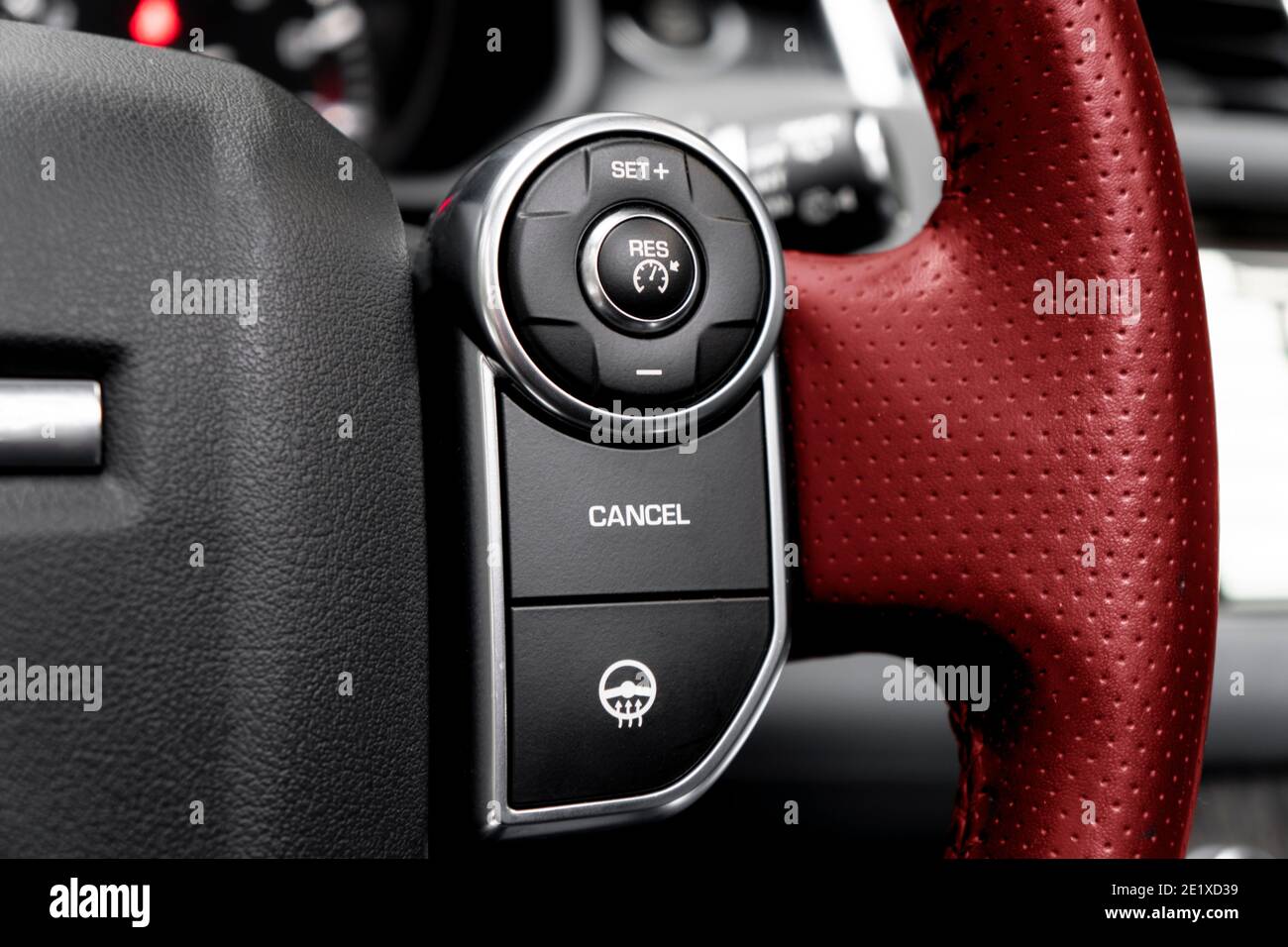 Cruise control buttons on the red perforated leather steering wheel of