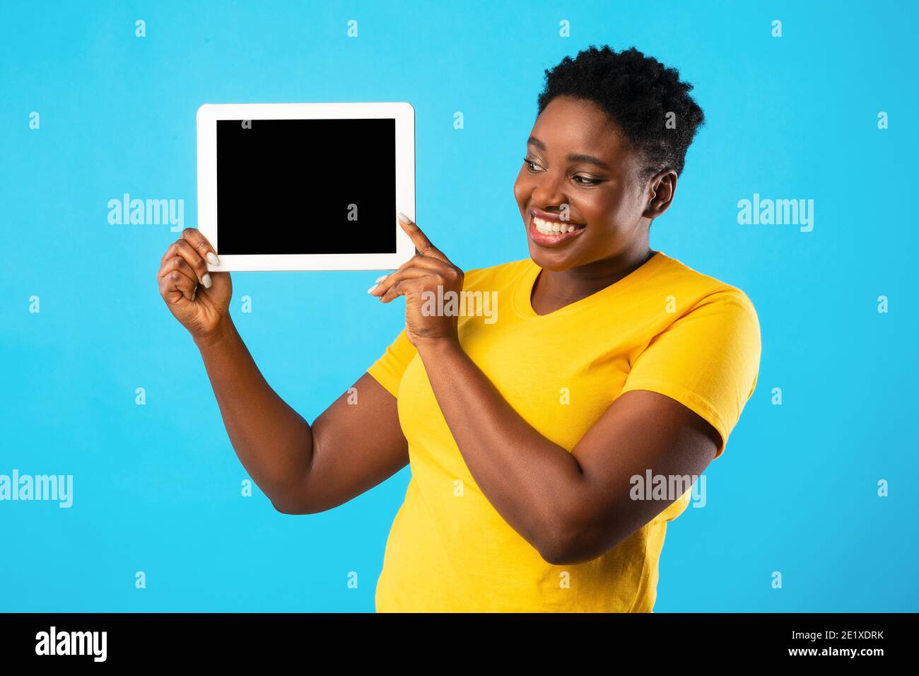 Smiling African Woman Showing Digital Tablet Screen Over Blue ...