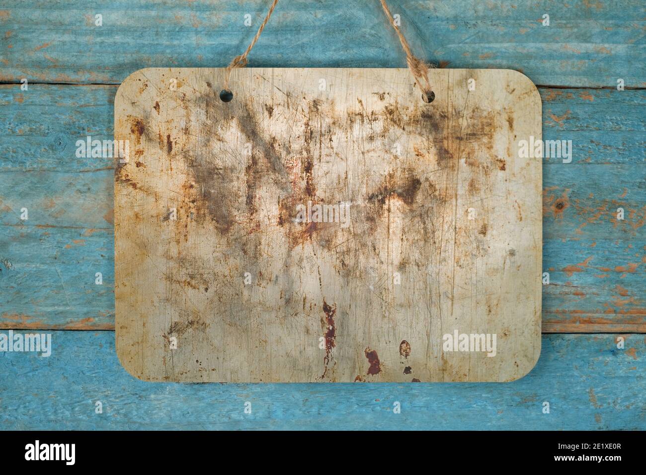 blank grungy metal sign hanging on blue wooden planks wall, free copy space Stock Photo