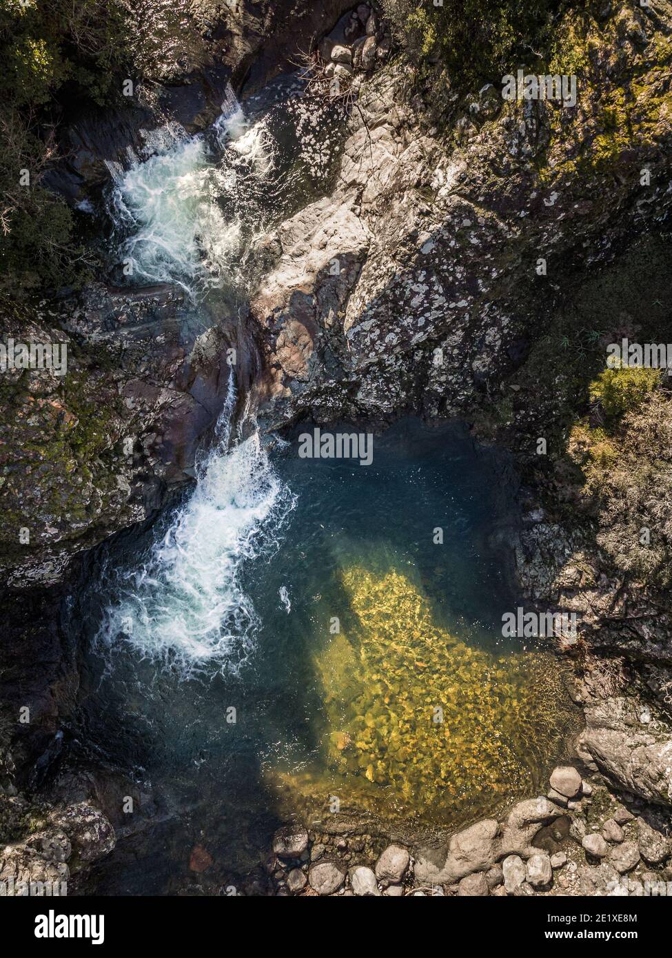 Aerial view of a mountain stream cascading into a clear pool at Pirio in Corsica Stock Photo