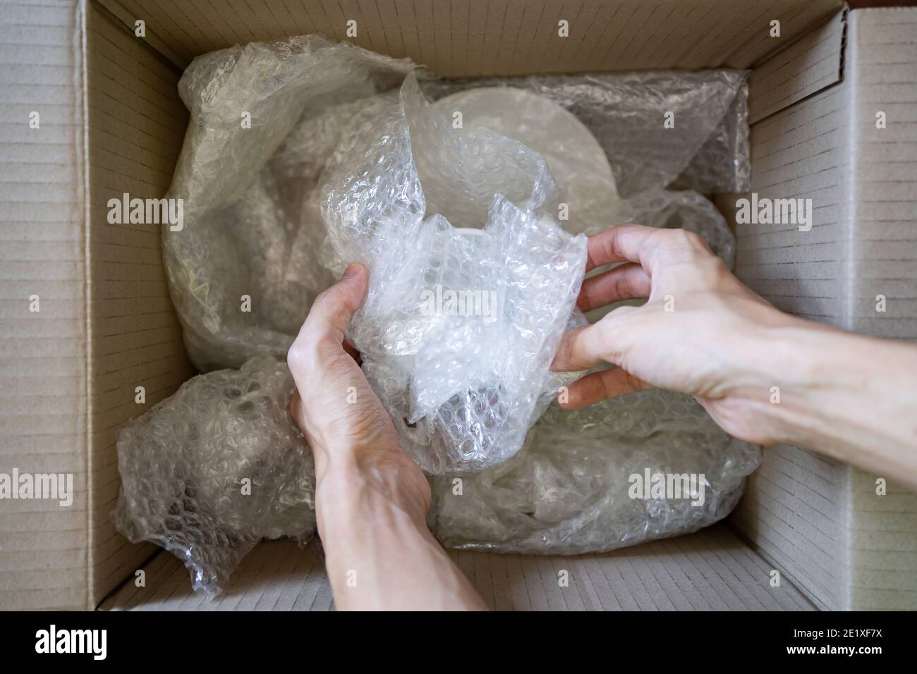 Wrapping a ceramic cup with bubble wrap Stock Photo Alamy