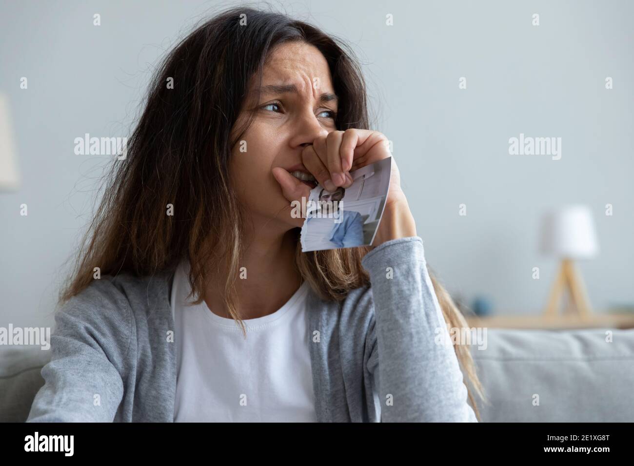 Close up crying woman holding picture of husband, break up Stock Photo