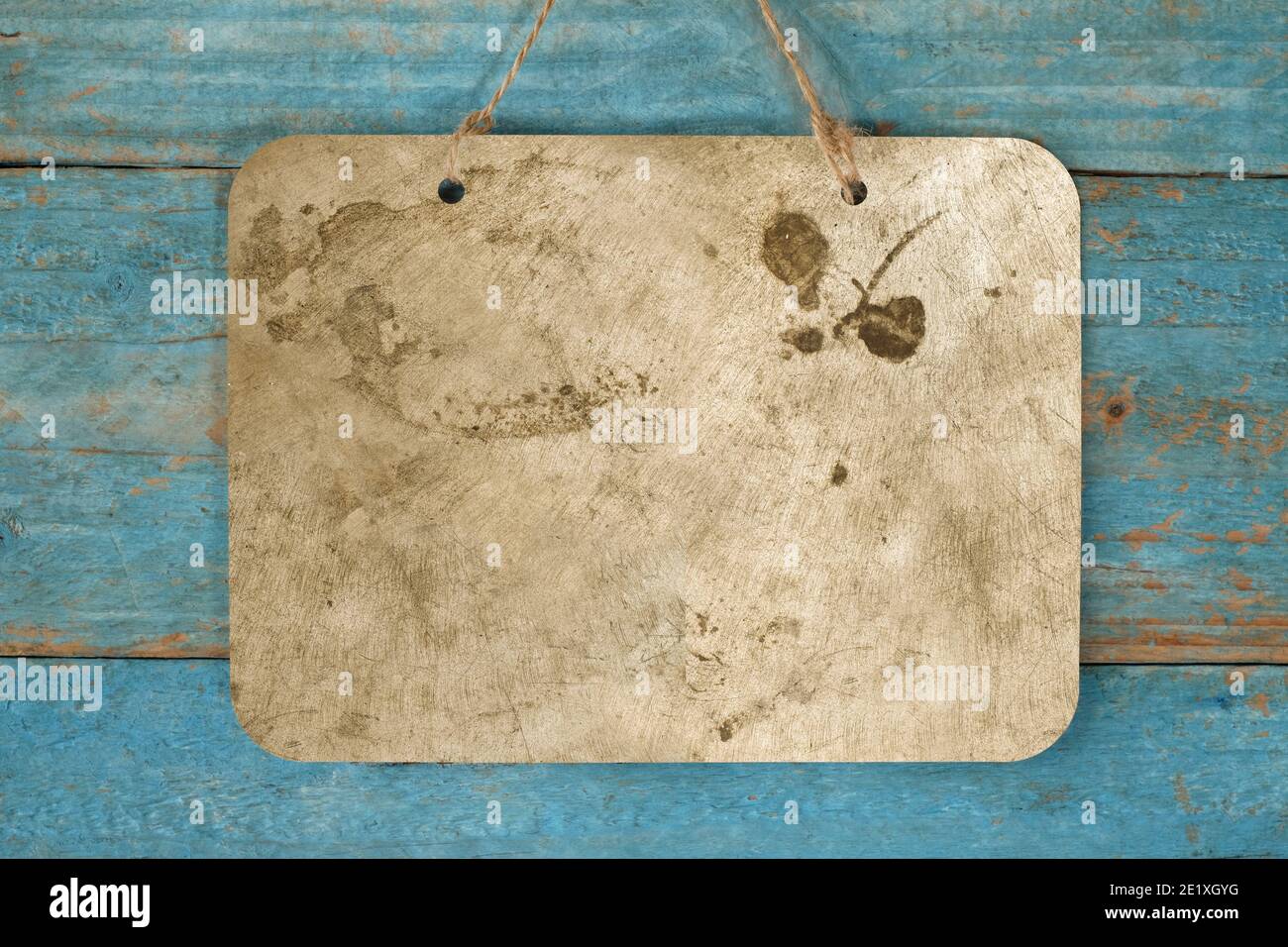 blank grungy metal sign hanging on blue wooden planks wall, free copy space Stock Photo