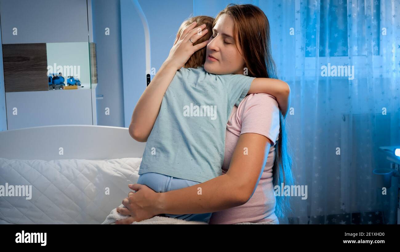 Young loving pregnant mother hugging and talking to her sad and scared