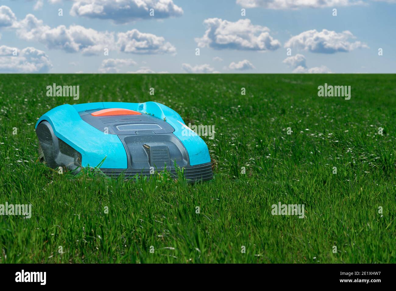 Autonomous lawnmower on the green lawn Stock Photo