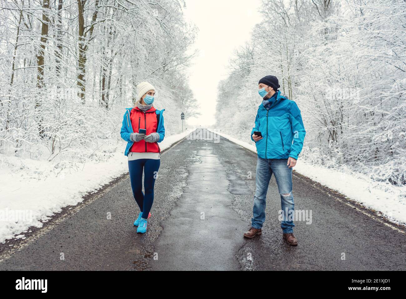 Man and woman social distancing in covid-19 winter Stock Photo