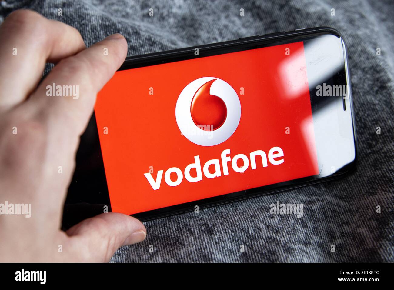Vodafone a largest telecommunication company. Hand holding iPhone 11 with Vodafone logo. Stock Photo