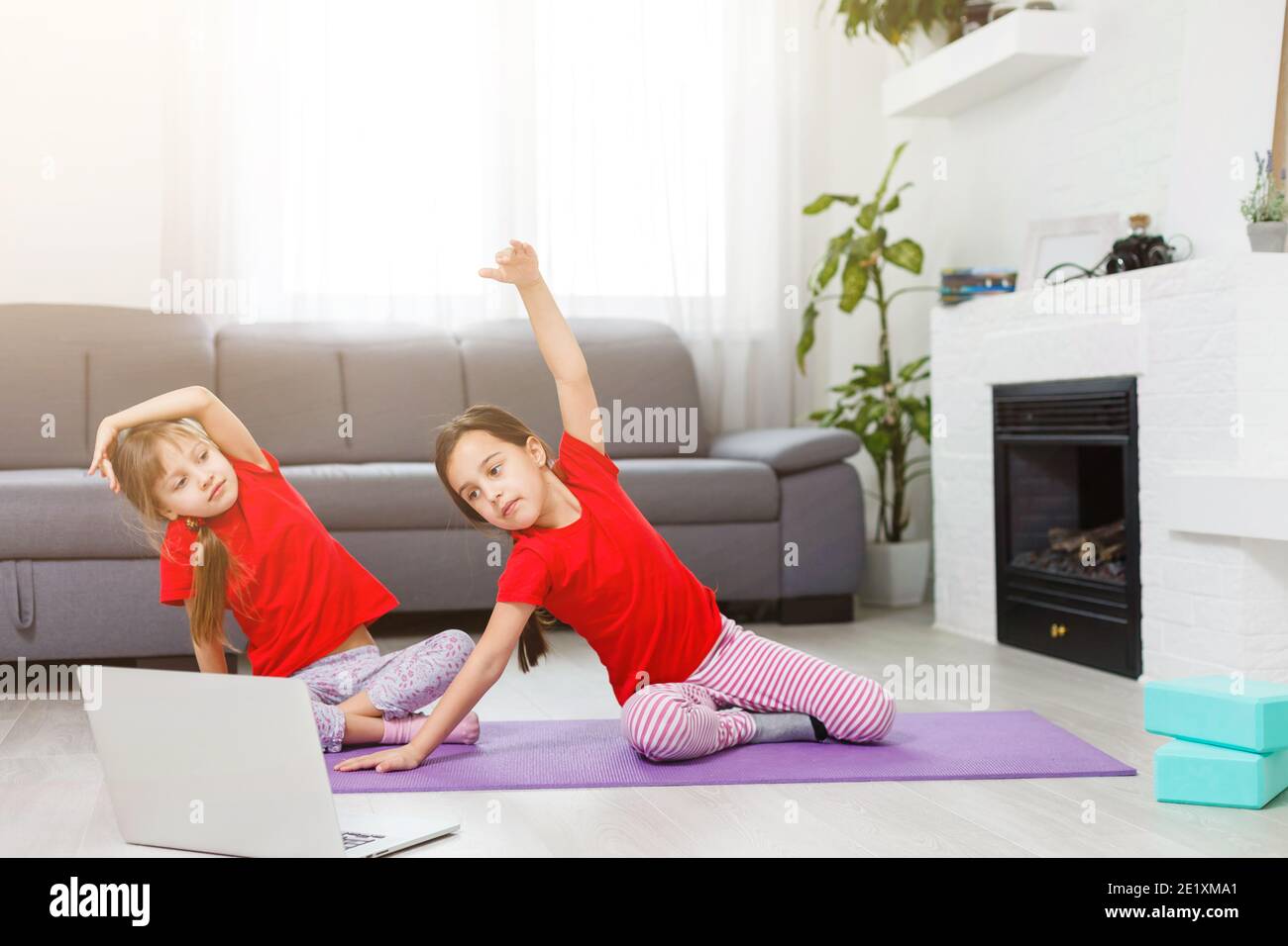 Little girl practicing yoga, stretching, fitness by video on notebook.  Distant online education training, aerobic at home. Healthy lifestyle,  coronavi Stock Photo - Alamy