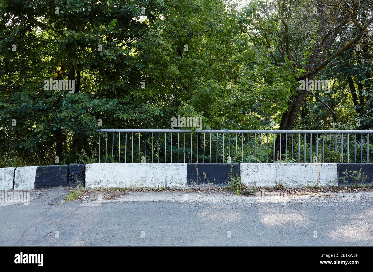 Barrier, designed to prevent the exit of the vehicle from the curb or bridge. Guarding rail on suburban road Stock Photo