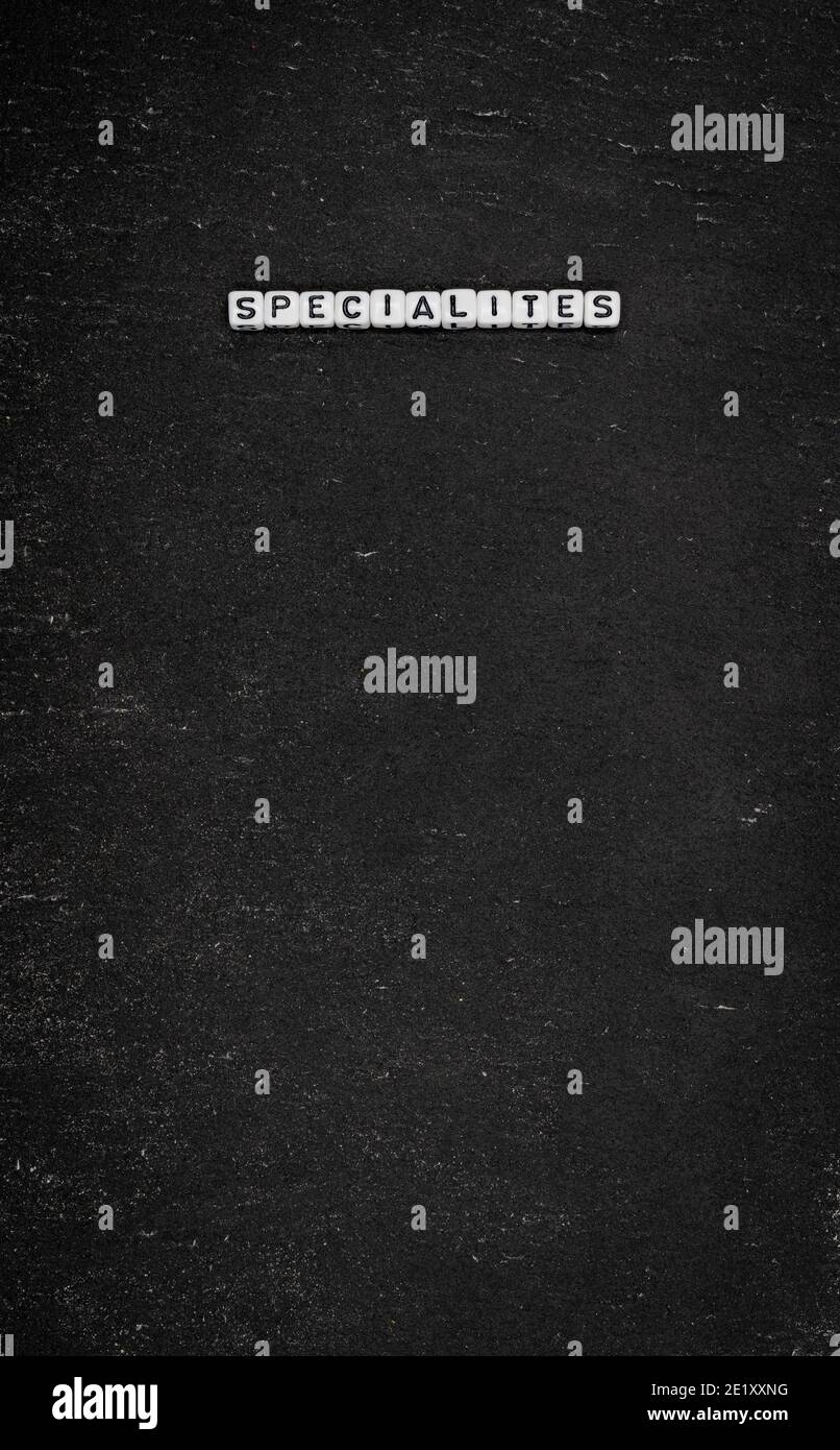 Word specialites on black stone background Stock Photo