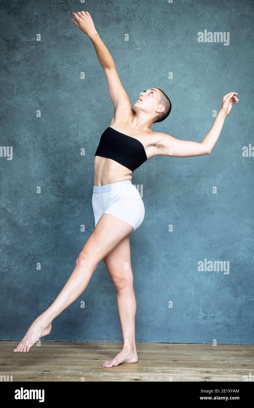 Non binary, gender neutral, biological female with shaved head, dances in  white men's underpants and black bandeau Stock Photo - Alamy