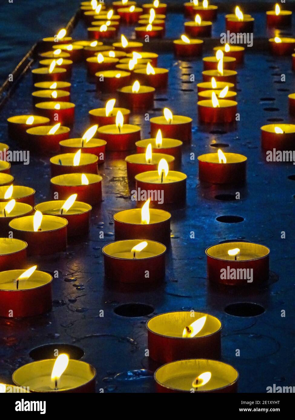 Close up of many tea lights shining in the dark sharing a warm mood Stock Photo