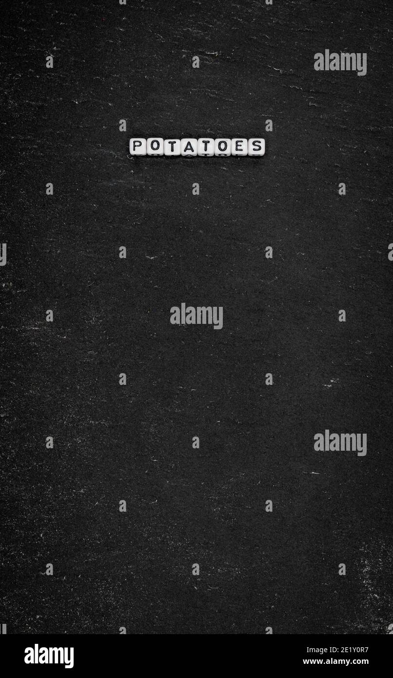 Word potatoes on black stone background Stock Photo