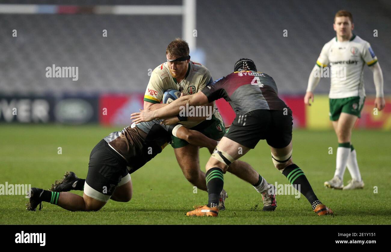 London Irish's Harry Elrington (centre) is tackled by Harlequins' Elia Elia (left) and Matt Symons (right) during the Gallagher Premiership match at Twickenham Stoop, London. Stock Photo