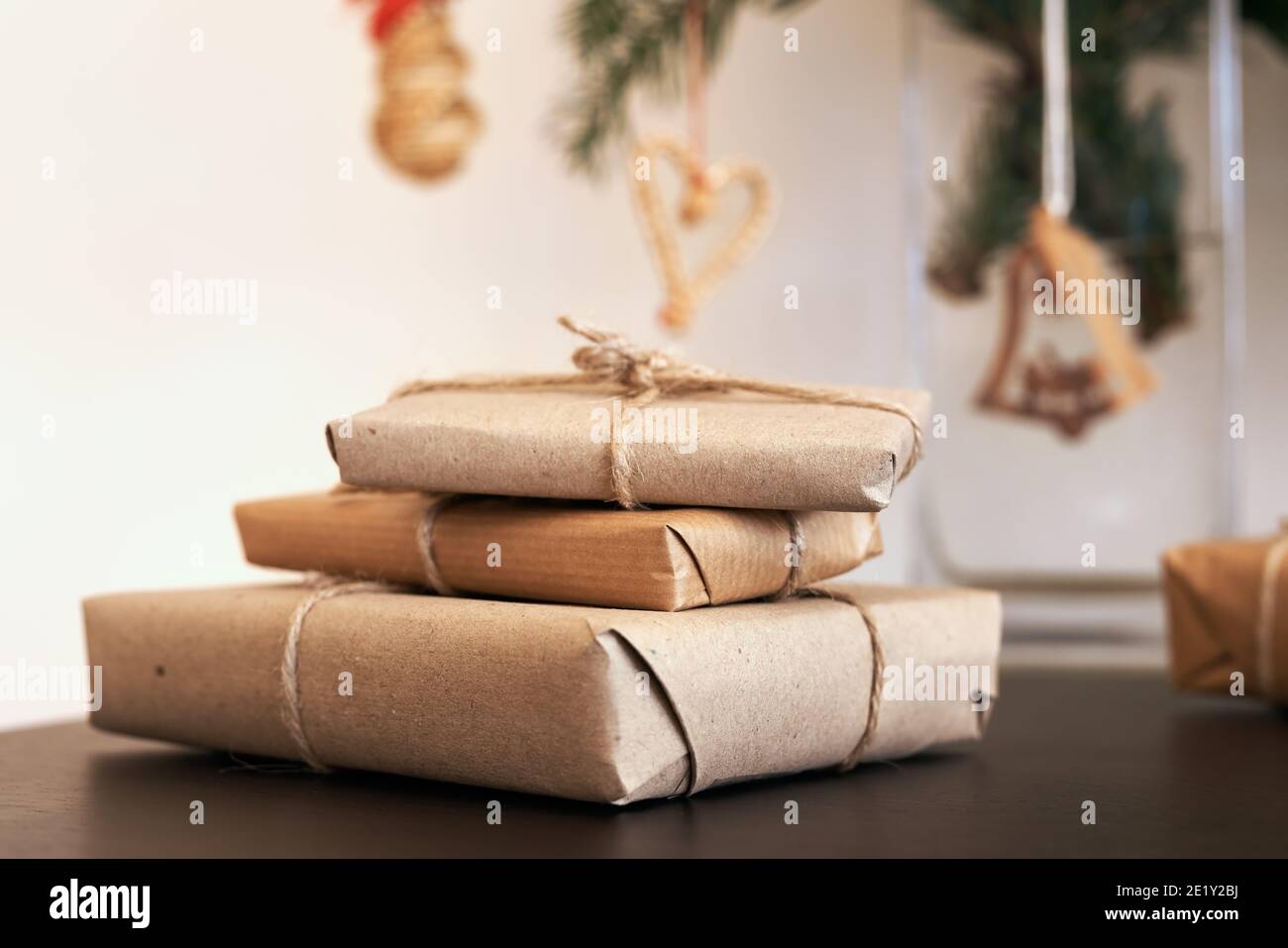 Christmas presents wrapped in ecological recycled paper with straw decoration in the background - zero-waste concept Stock Photo