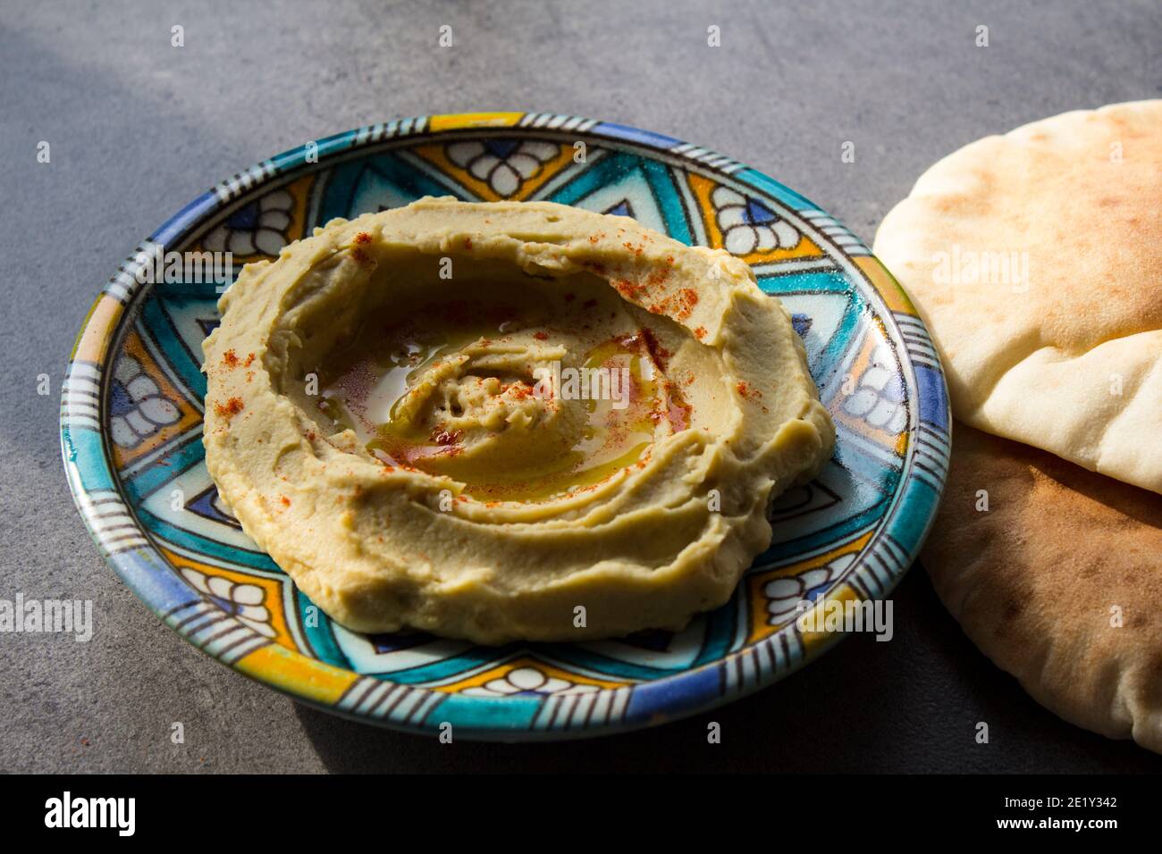 Tasty hummus on colorful plate. Top view photo of traditional food of Israel. Balanced diet concept.  Classic israeli hummus. Stock Photo