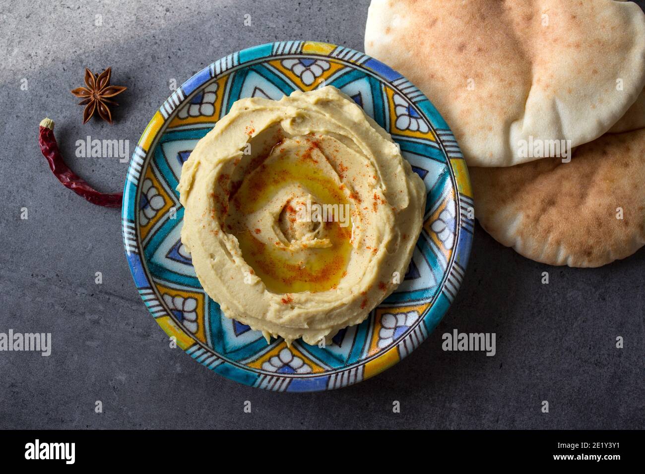 Tasty hummus on colorful plate. Top view photo of traditional food of Israel. Balanced diet concept.  Classic israeli hummus. Stock Photo