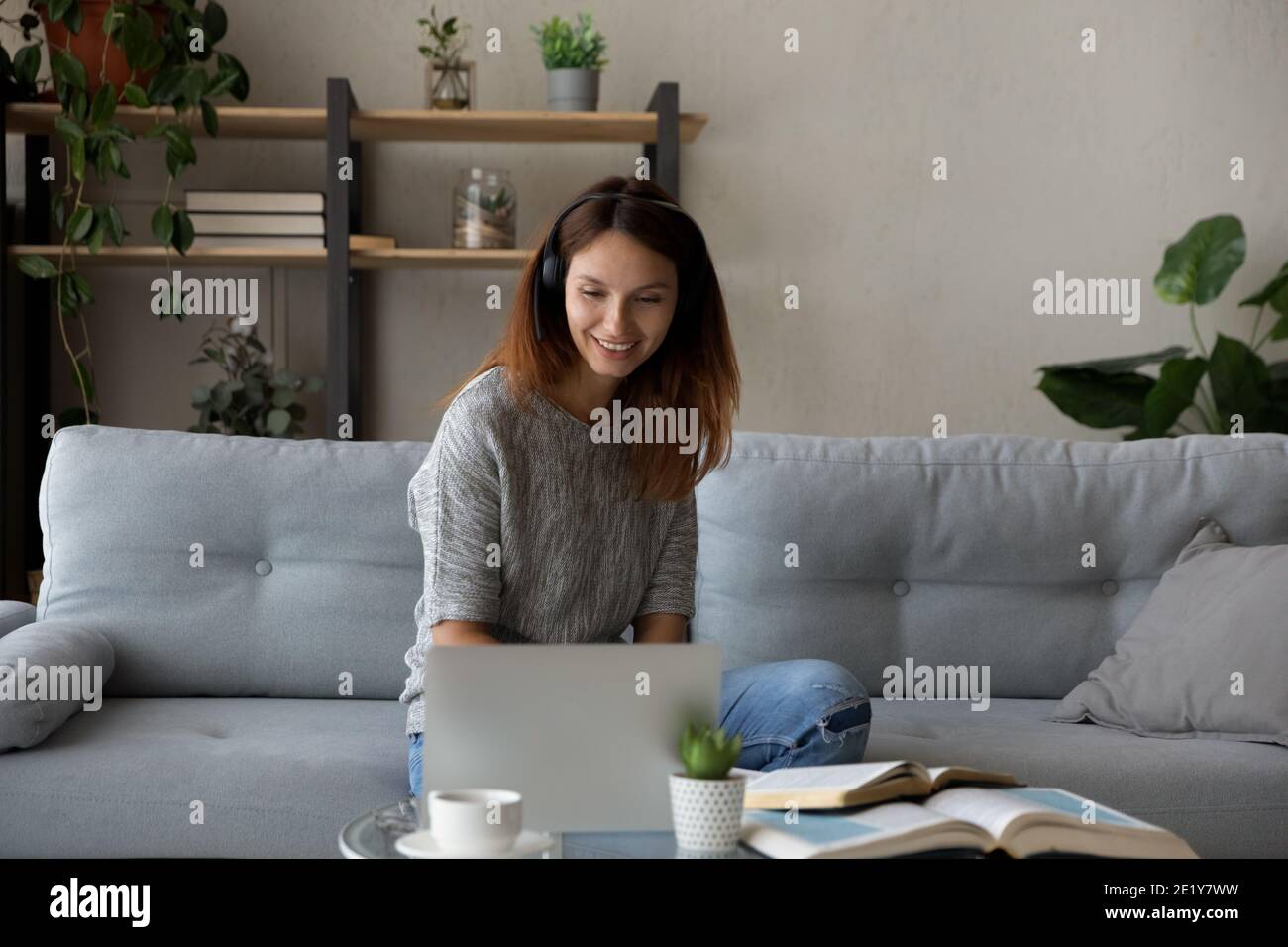Smiling woman in headphones study online at home Stock Photo