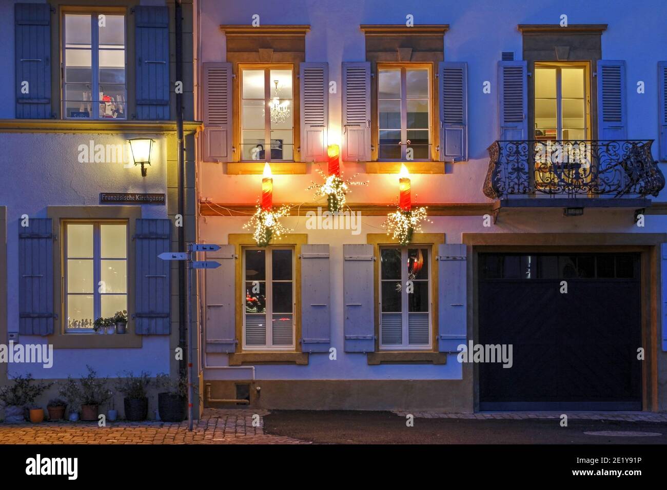Three candle like illumination adorn the facade of a beautiful historic house in Murten (or Morat in French) in Fribourg Canton of Switzerland during Stock Photo