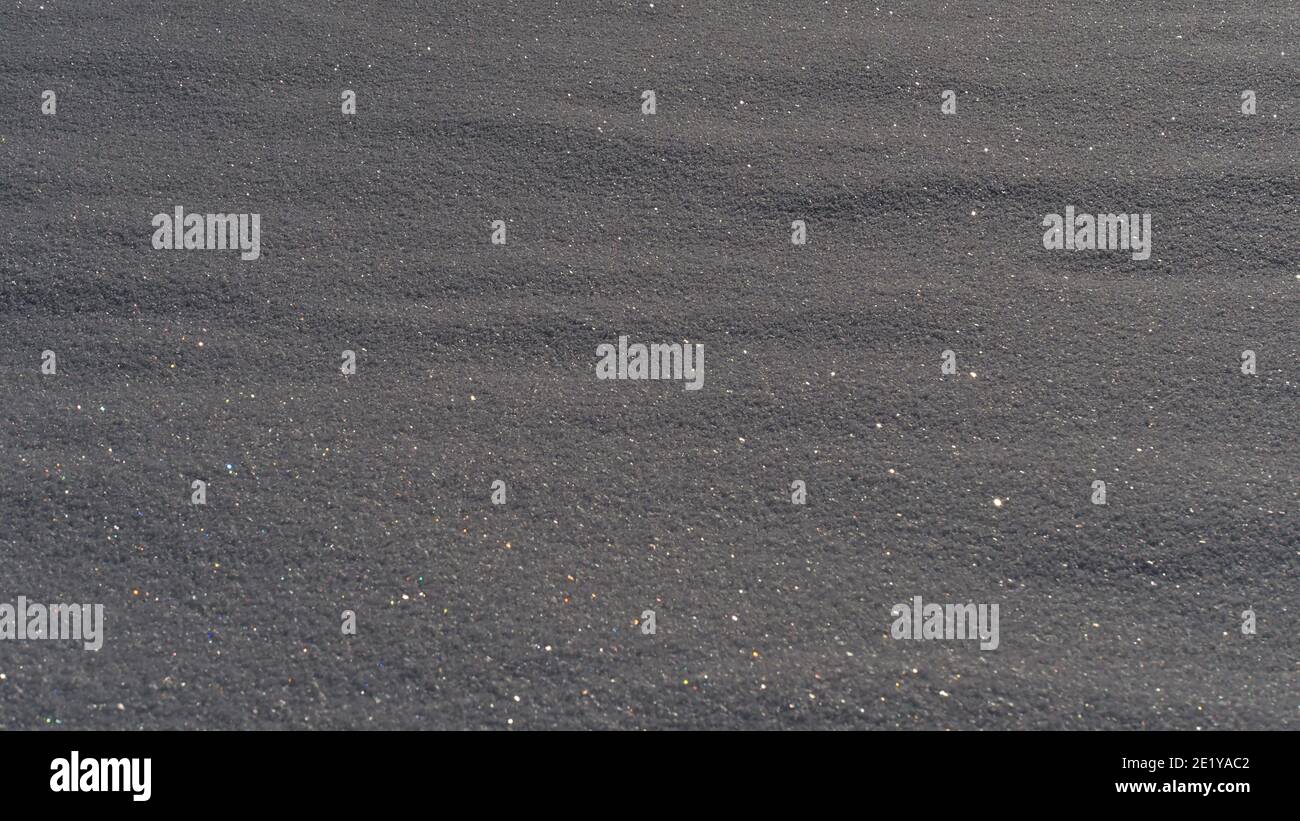 Closeup view with beautiful pattern of snow cover on a field with ice crystals glittering in the sunlight in winter season. Focus on center of image. Stock Photo