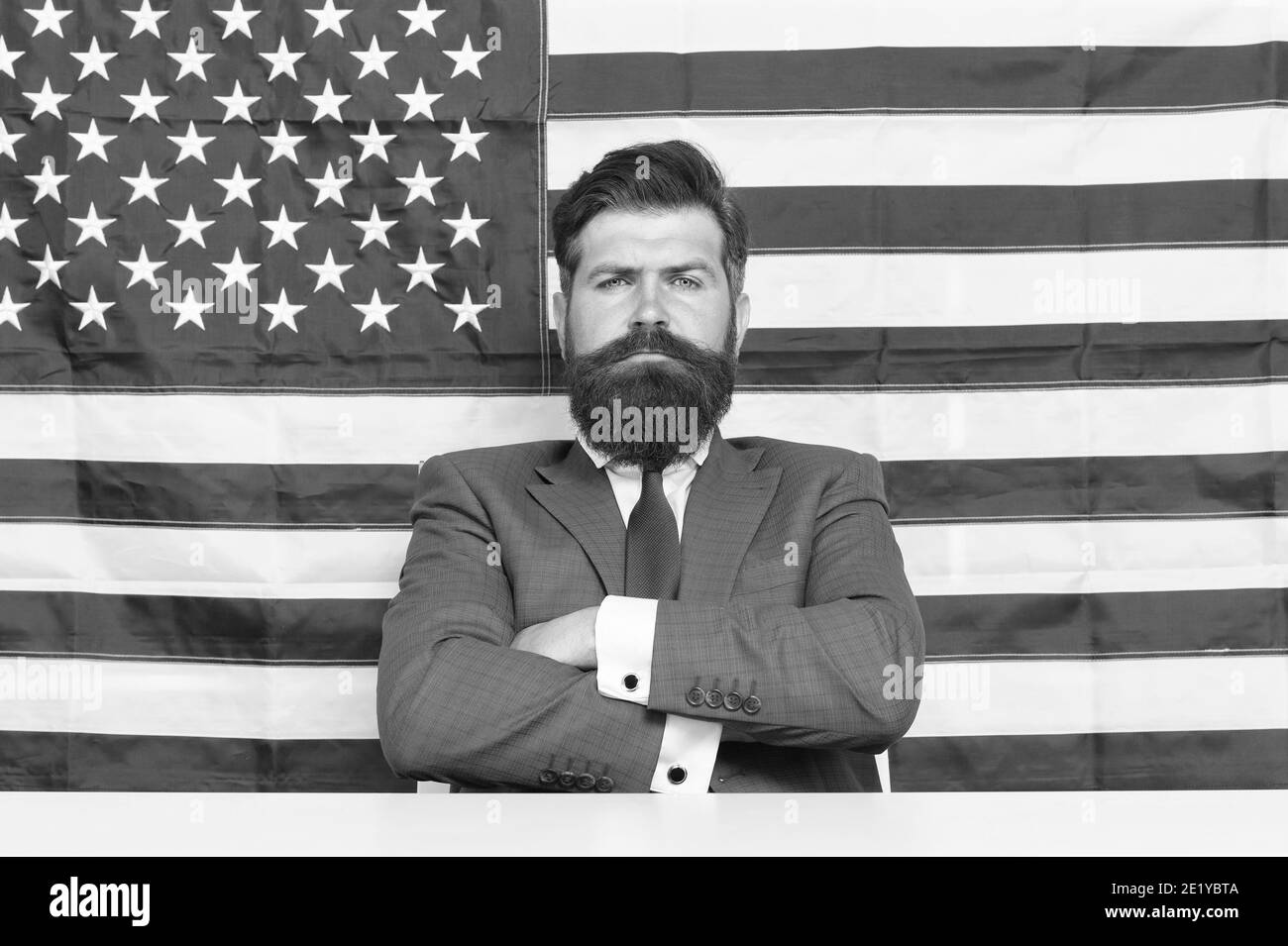 Confident in future of his country. Confident american keep arms crossed. Confident look of serious businessman. Independence day. July 4th. USA flag background. Proud and confident. Stock Photo