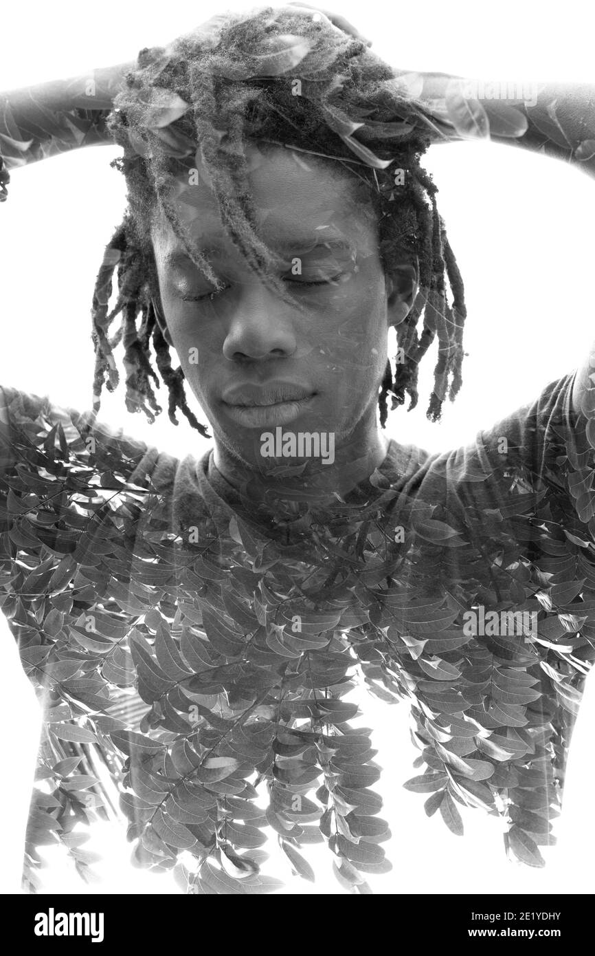 A double exposure portrait of a man with closed eyes in black and white ...
