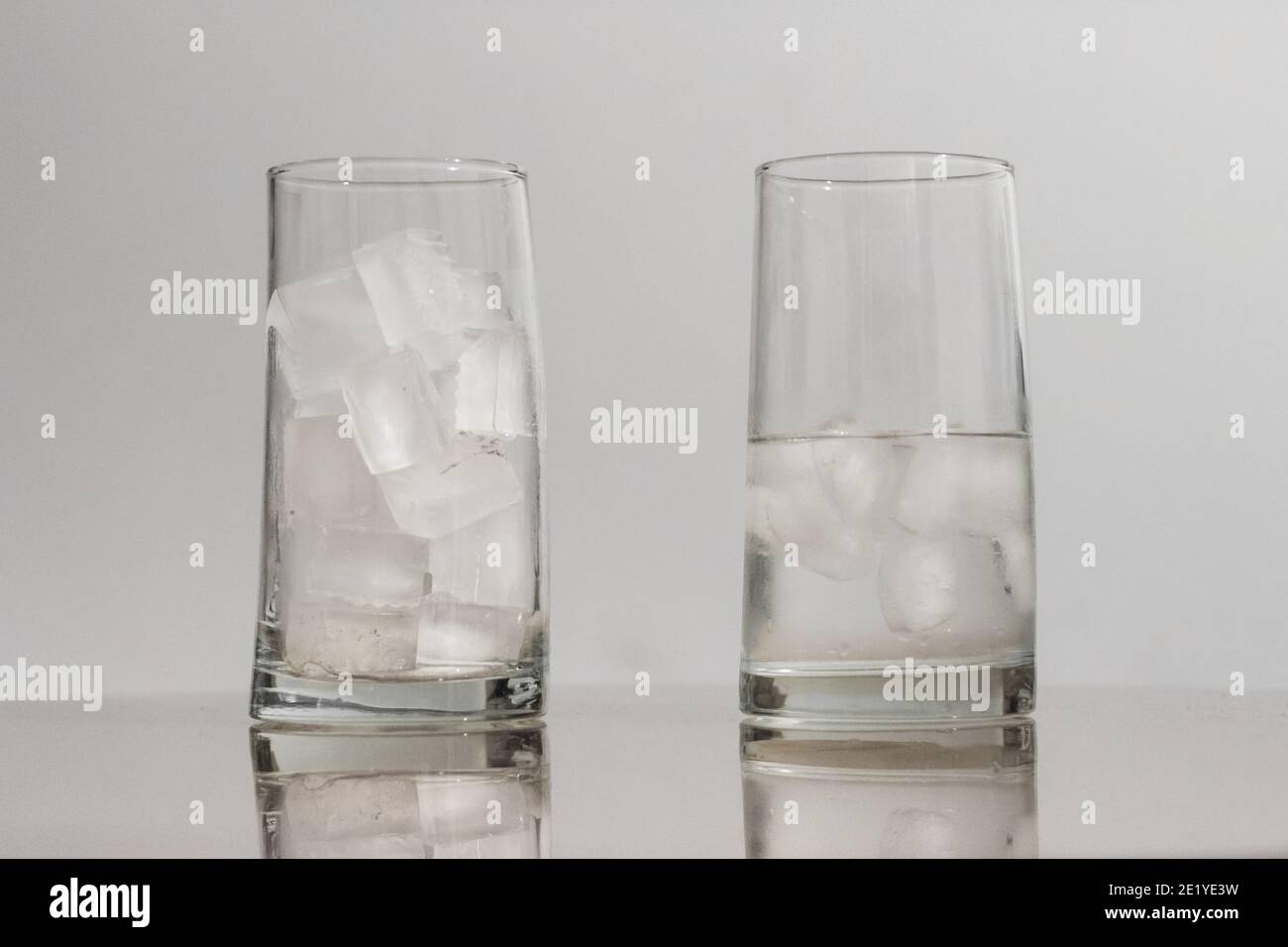 Glasses with melted ice with water and ice representing global warming Stock Photo