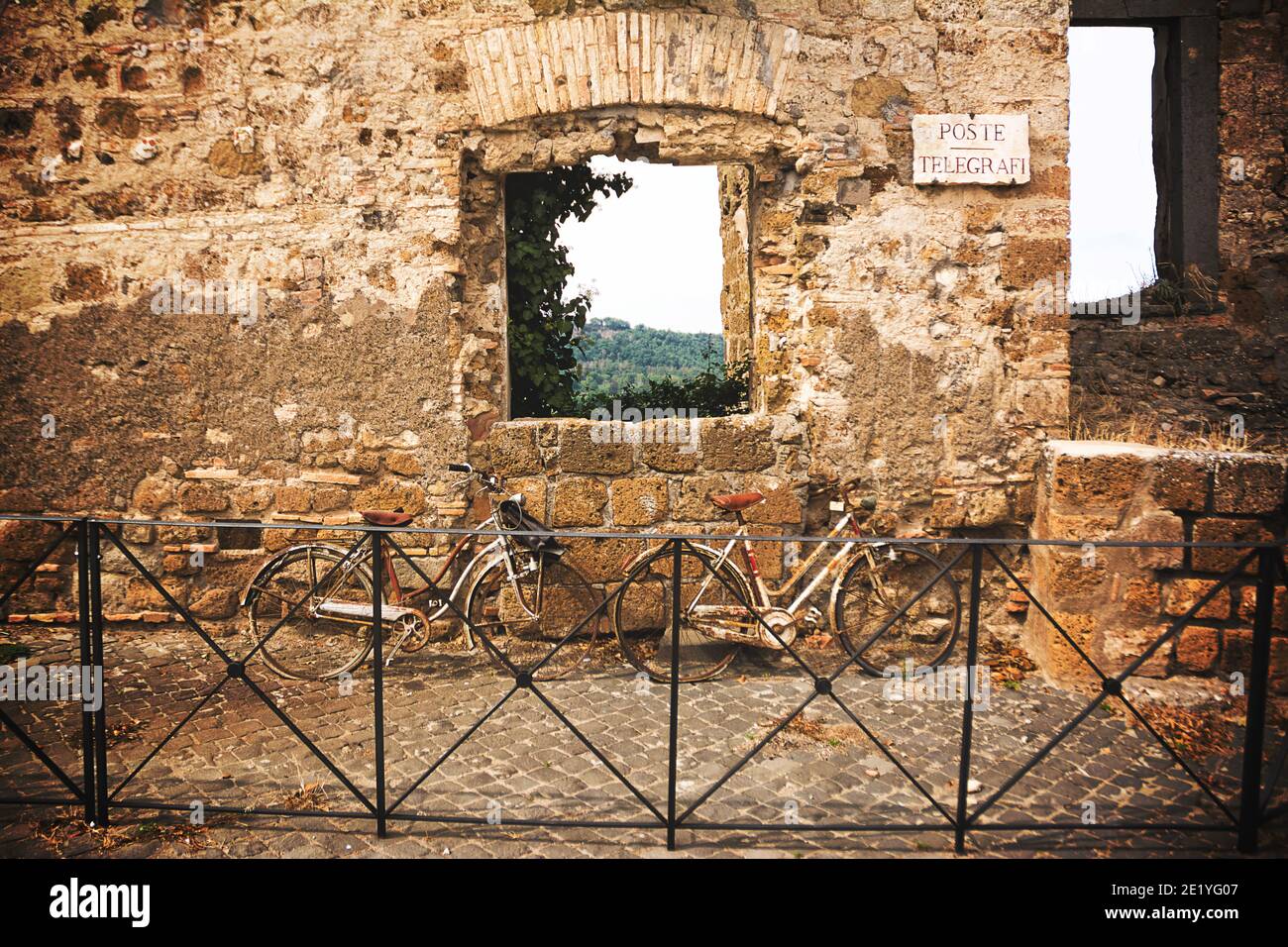 Old bicycles leaning on the old wall with the inscription 'Poste e Telegrafi' (Mail e Telegraph) Stock Photo