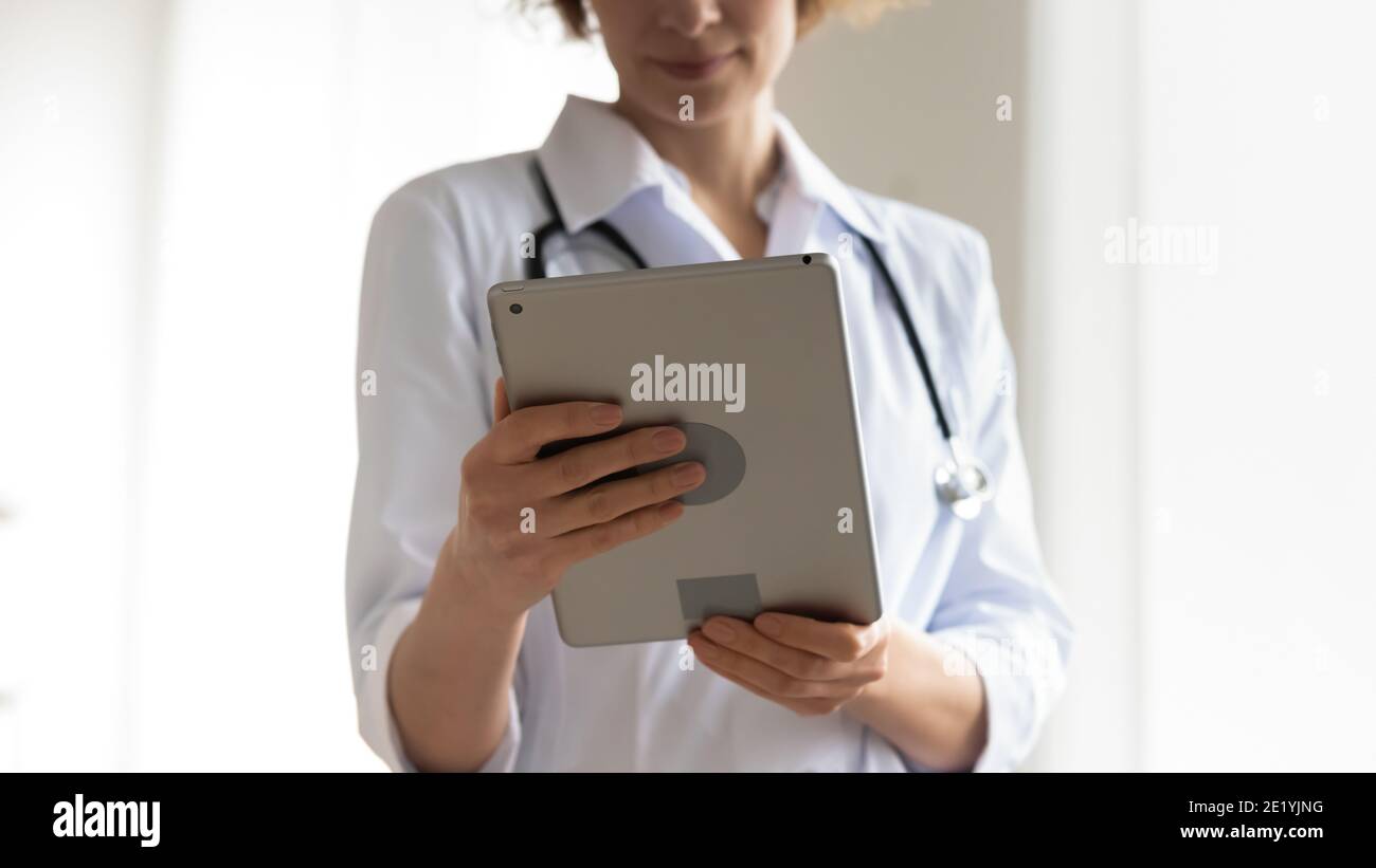 Close up young female physician using digital tablet. Stock Photo
