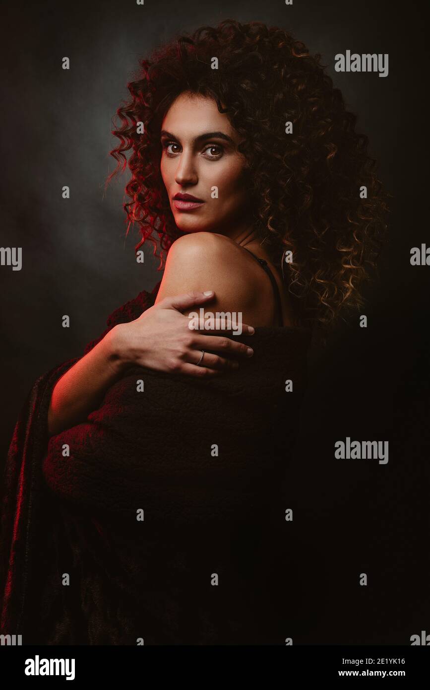 Beautiful curly afro girl on black background and red