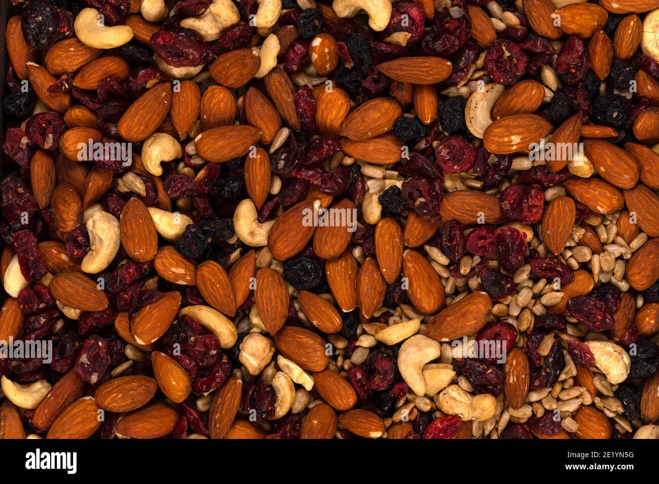 Macro of trail mix with almonds, sunflower seeds, cranberry and raisins