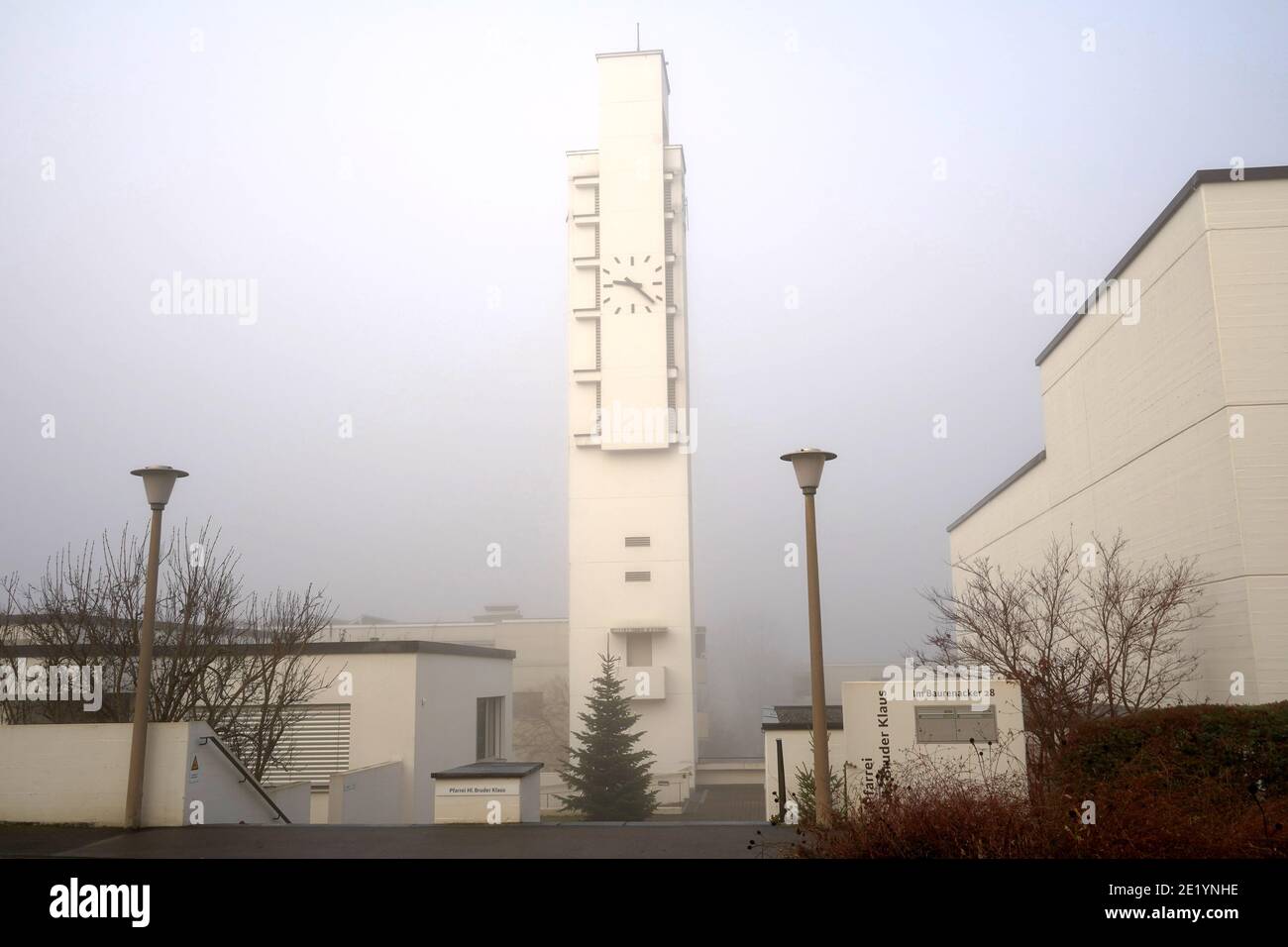 Parish of Saint Brother Klaus in Urdorf, Roman Catholic Church in horizontal view close up, in winter at sunrise. Modern style architecture in white. Stock Photo