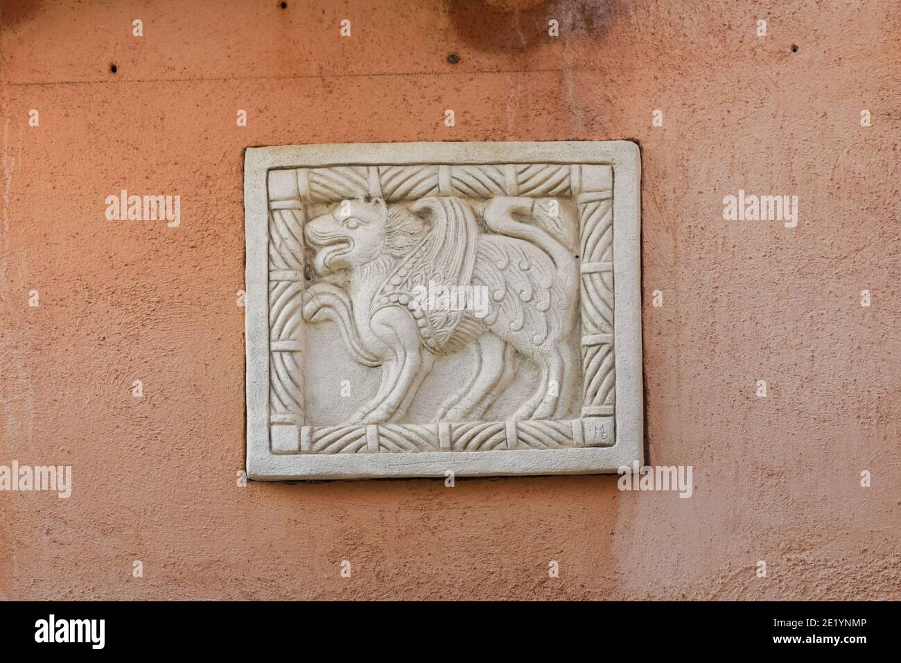 Lion of Saint Mark relief on the wall of a building in Venice, Italy Stock Photo