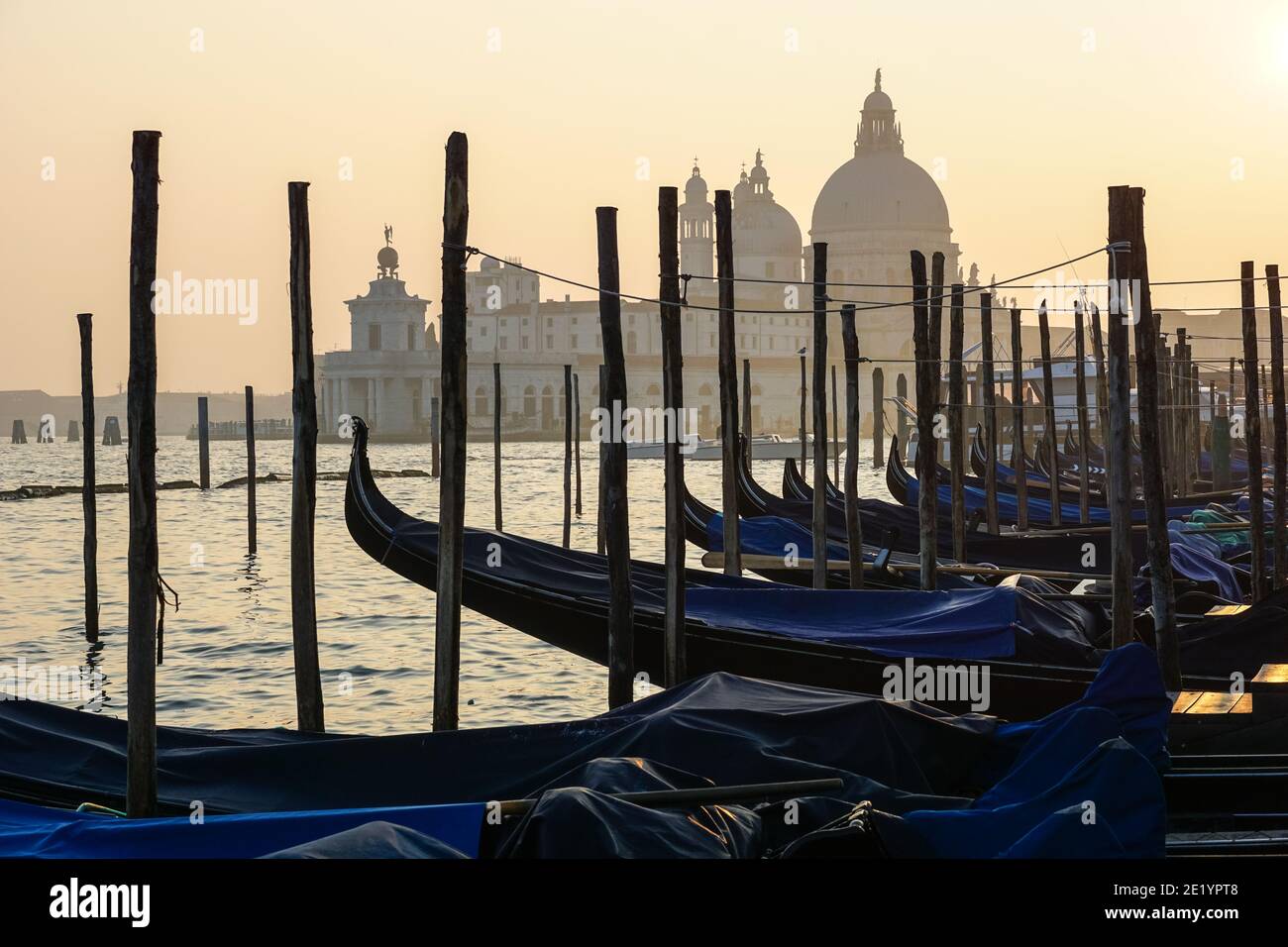 Venetian gondola at sunset, gondolas moored in Venice with Santa Maria della Salute basilica in the background, Italy Stock Photo