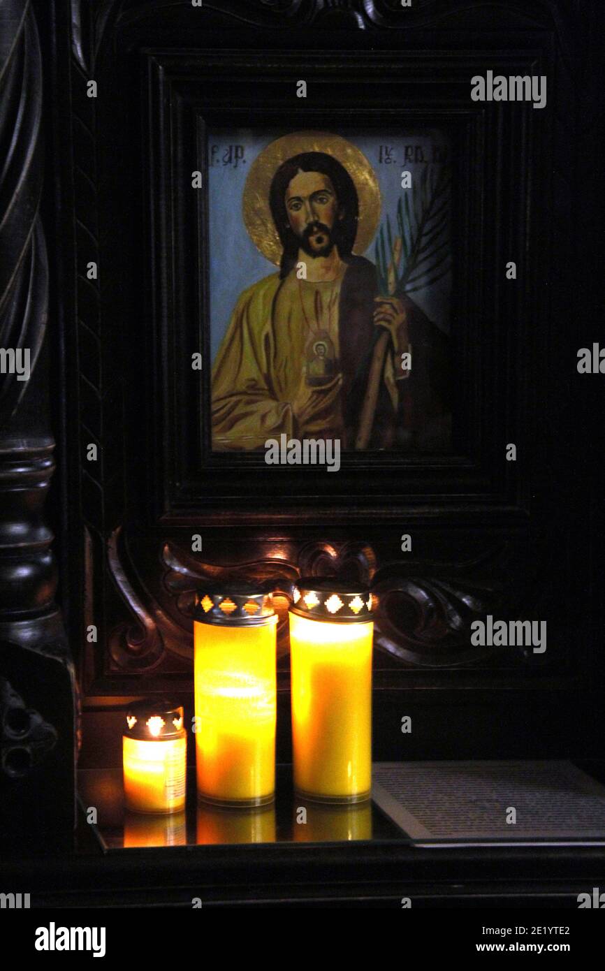 Candles burning in front of an icon of Jesus Christ inside a Christian