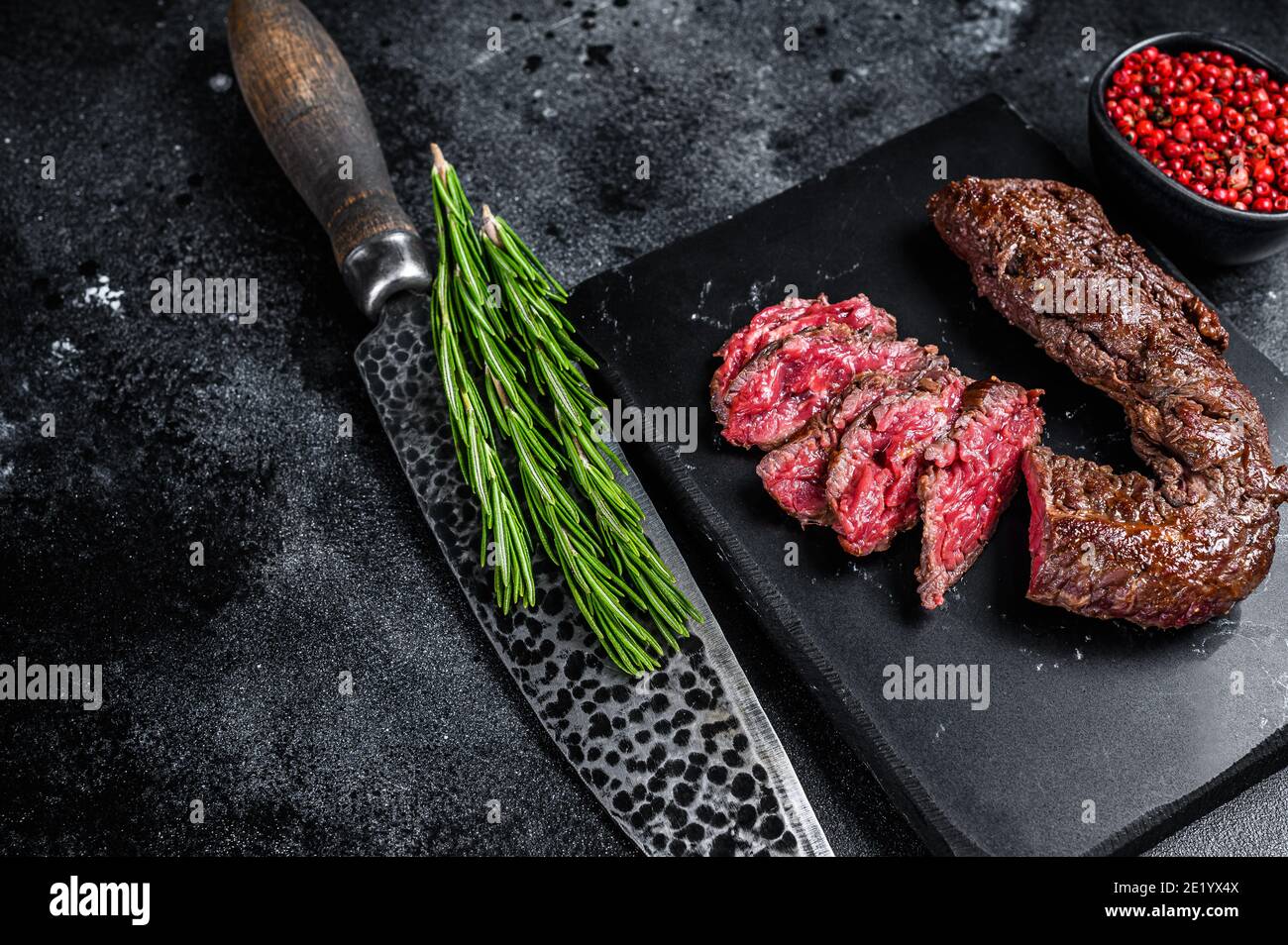 Sliced grilled Onglet Hanging Tender steak on a marble board. Black background. Top view. Copy space Stock Photo