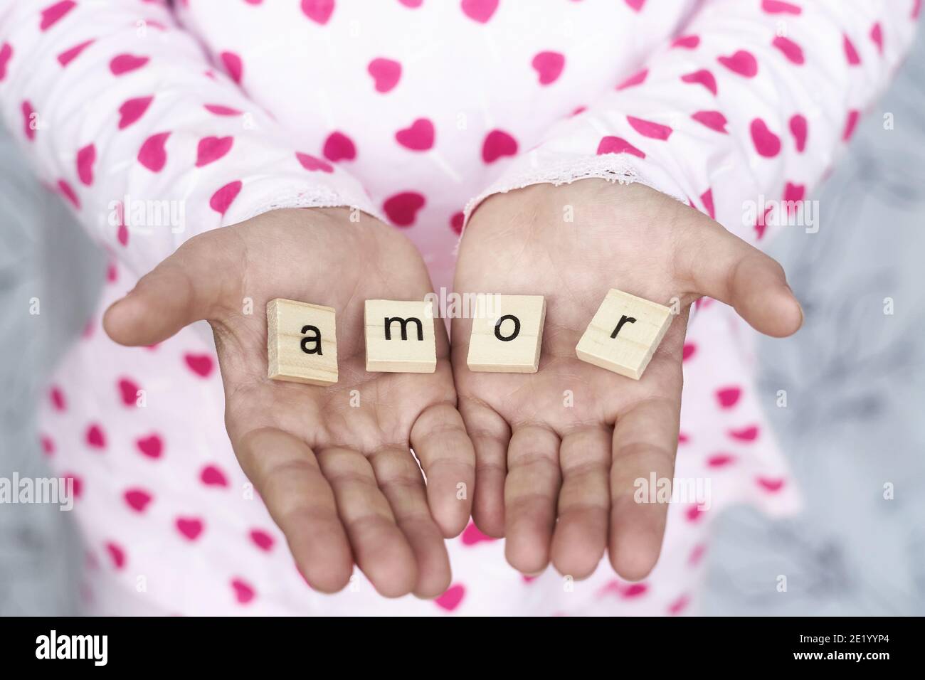 girl holds the word amor in her hands , selective focus Stock Photo