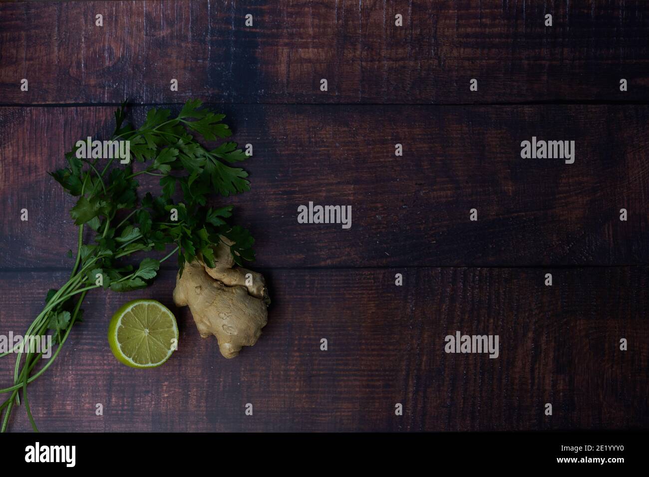 Fresh ingredients on wooden board. lime, coriander, parsley. Stock Photo