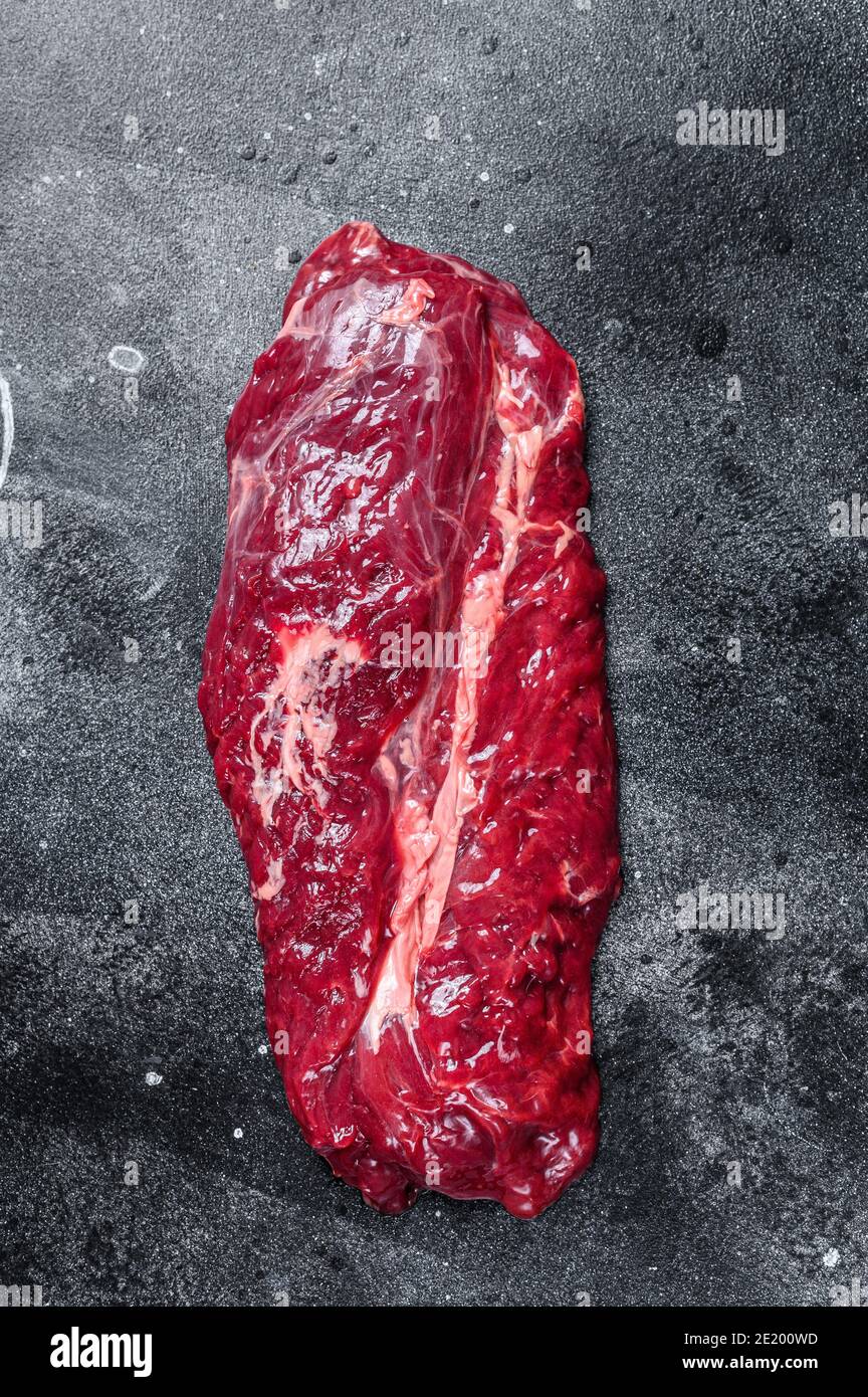 Raw Hanging Tender beef meat steak. Black background. Top view Stock Photo