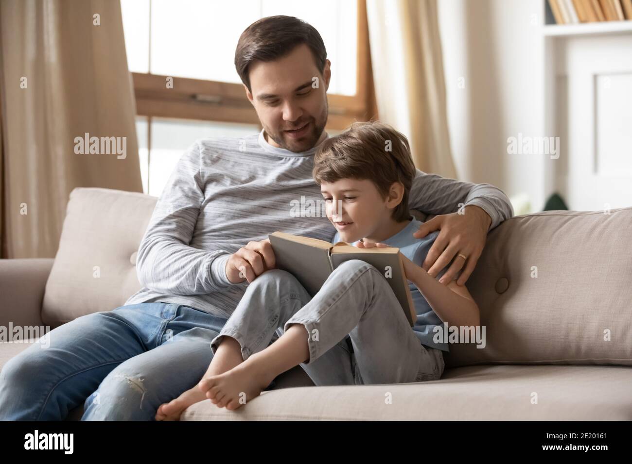 Happy dad and small son read book at home Stock Photo