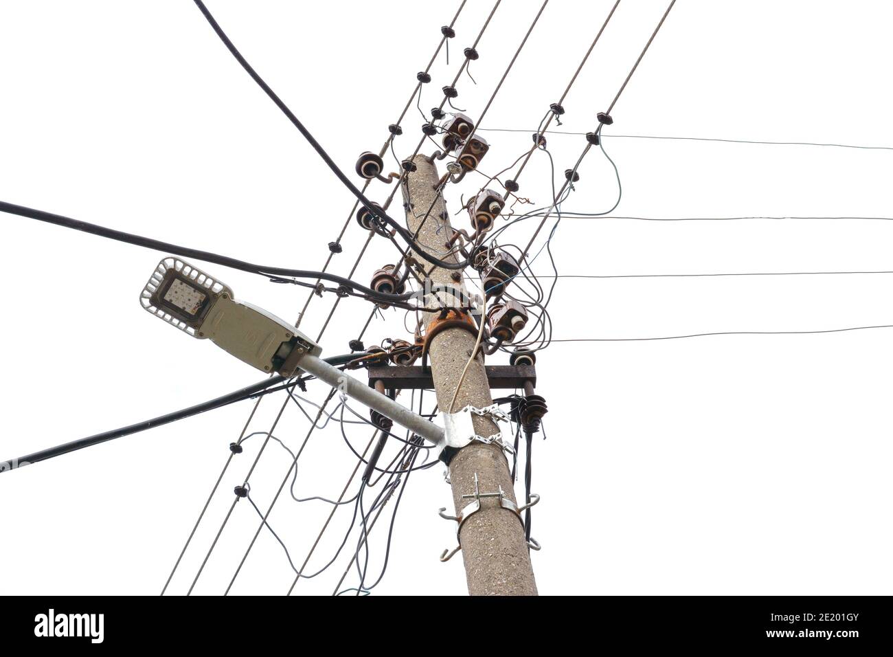 Many electric wires on concrete street pole with internet or cell phone communication box. Stock Photo