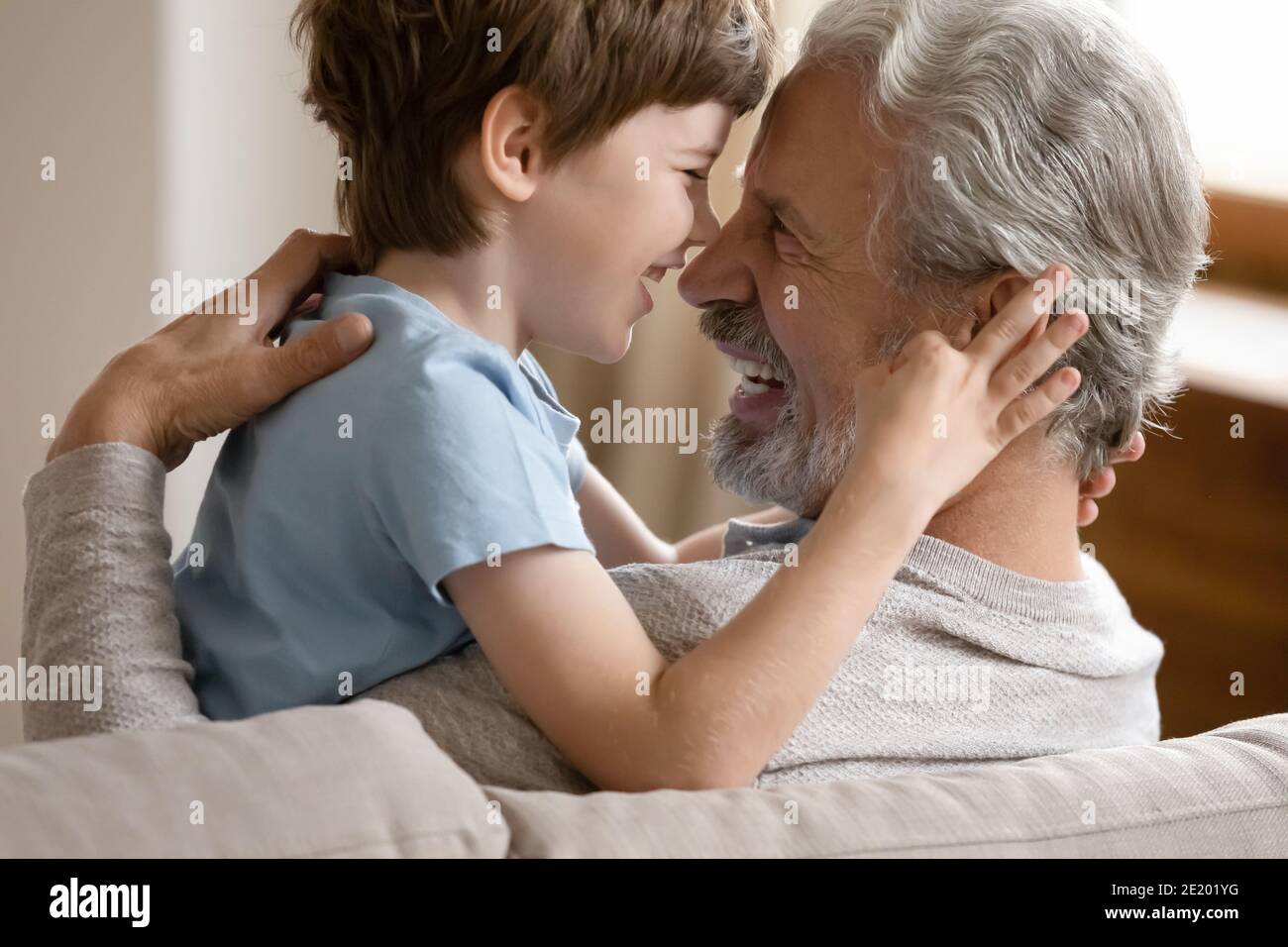 Happy small boy hug smiling mature grandfather Stock Photo