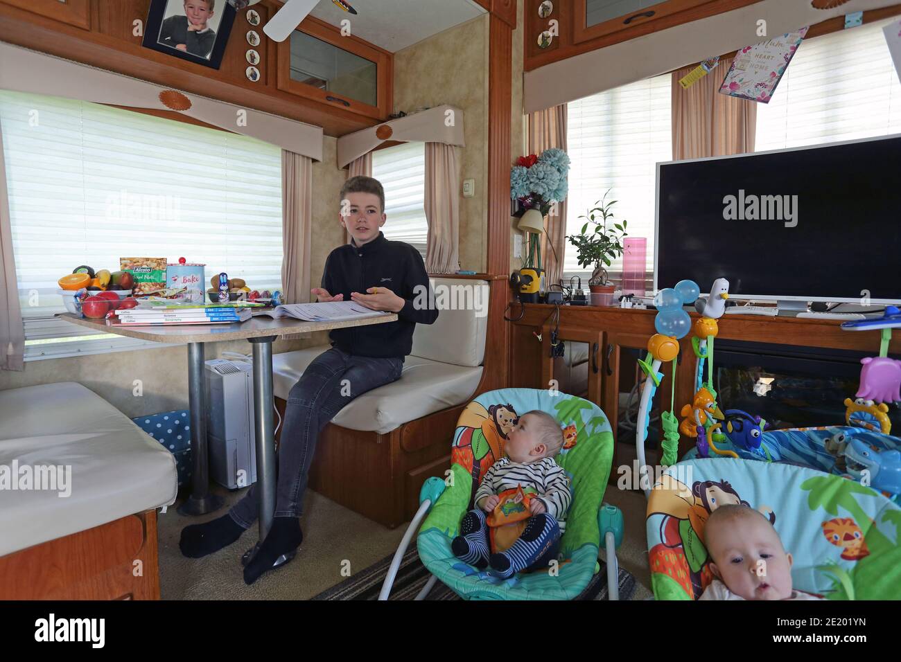 United Kingdom / Newport Pagnell /Pinders Circus / Boy doing his homework in caravan. Stock Photo
