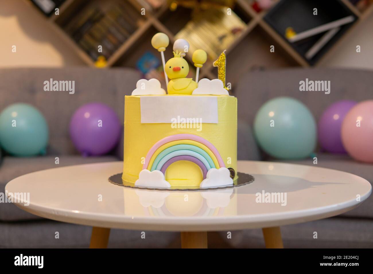 First birthday cake with little chicken and rainbow. White copy space on front Stock Photo