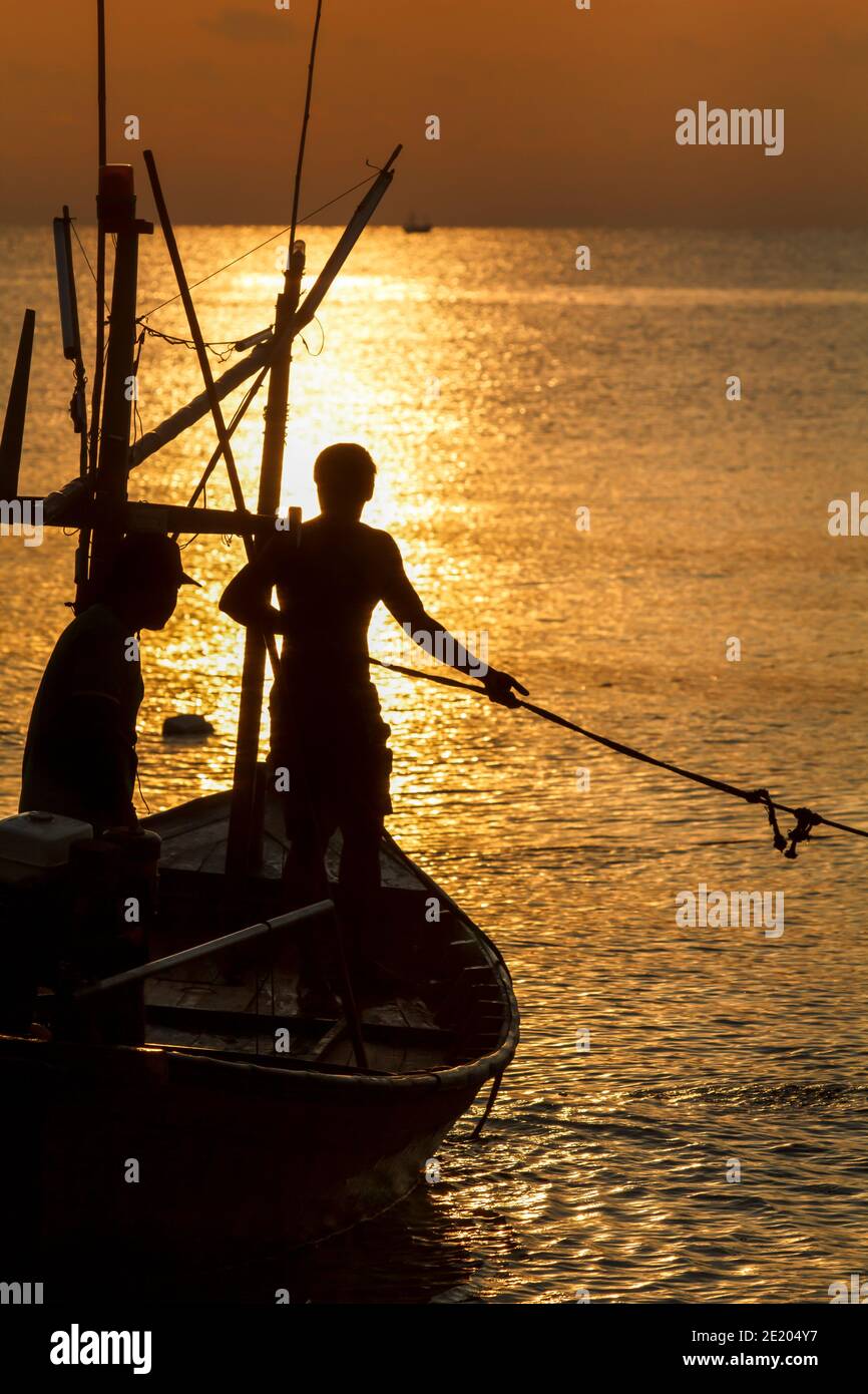 Fisherman silhouette in sea at sunrise Stock Photo - Alamy