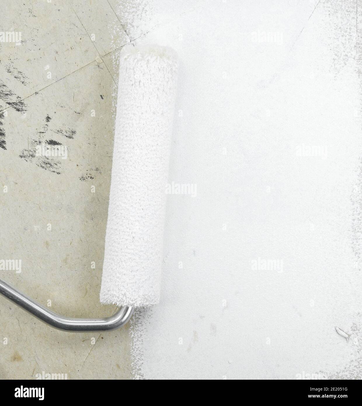 Painting a rough wall with roller. Paint roller leaving stroke of white