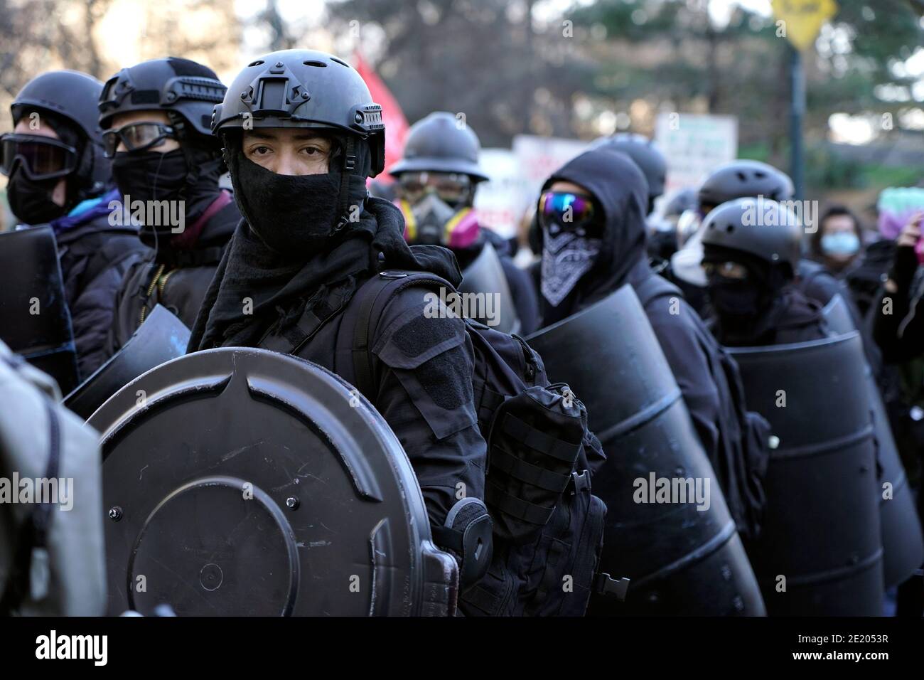 Members of an anti-fascist group in riot gear march through the streets ...