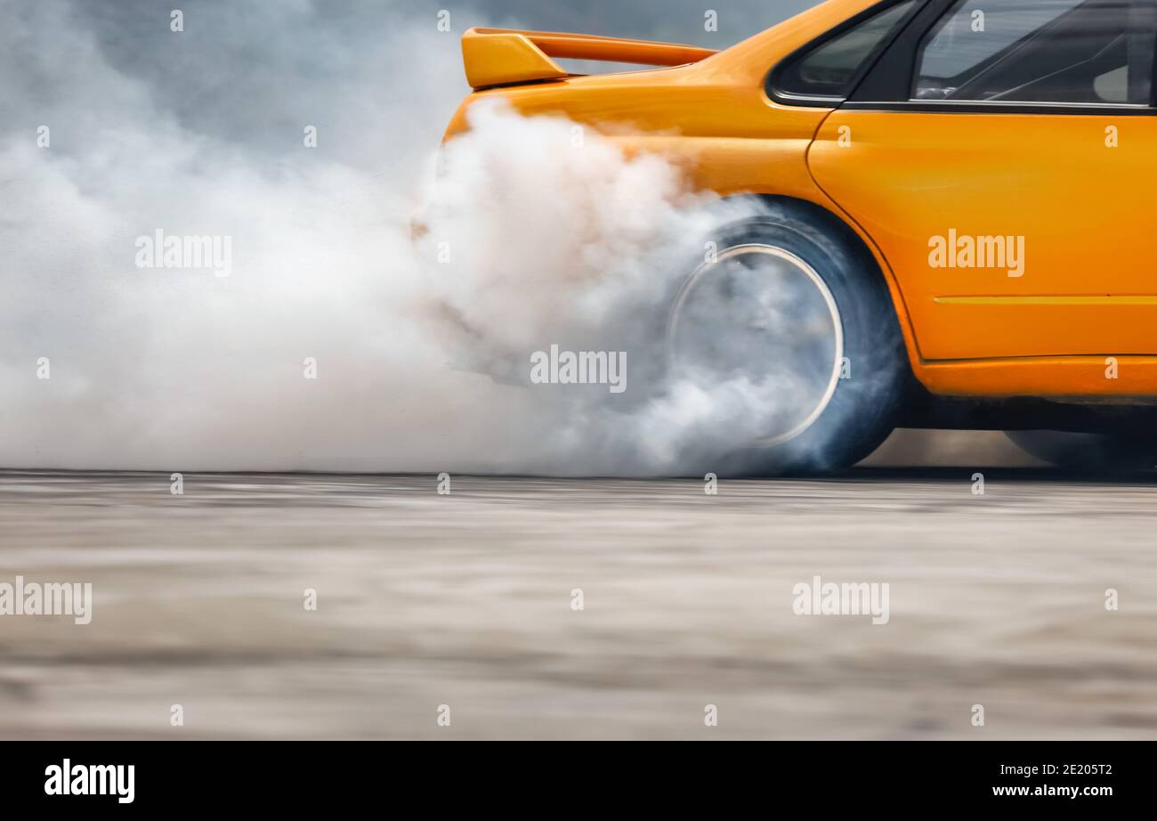 Car drifting, Blurred of image diffusion race drift car with lots of smoke  from burning tires on speed track Stock Photo